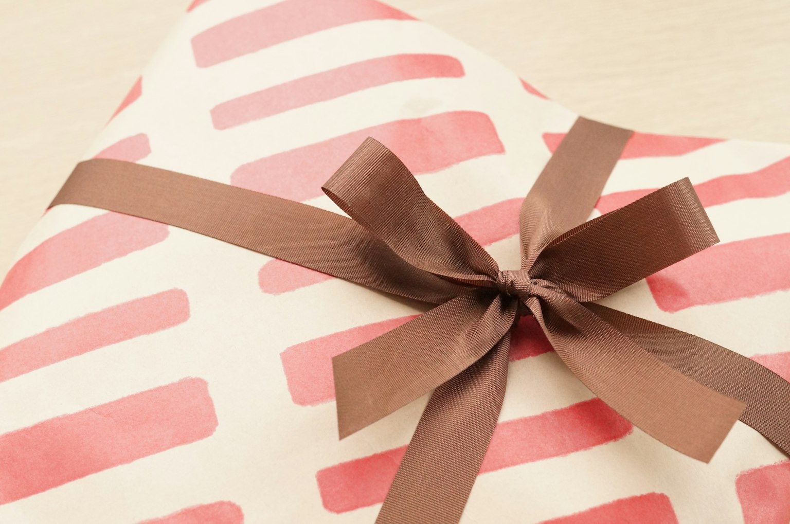 Eine Geschenkbox, die in rotem gestreiften Papier eingewickelt ist, mit einem braunen Band darum