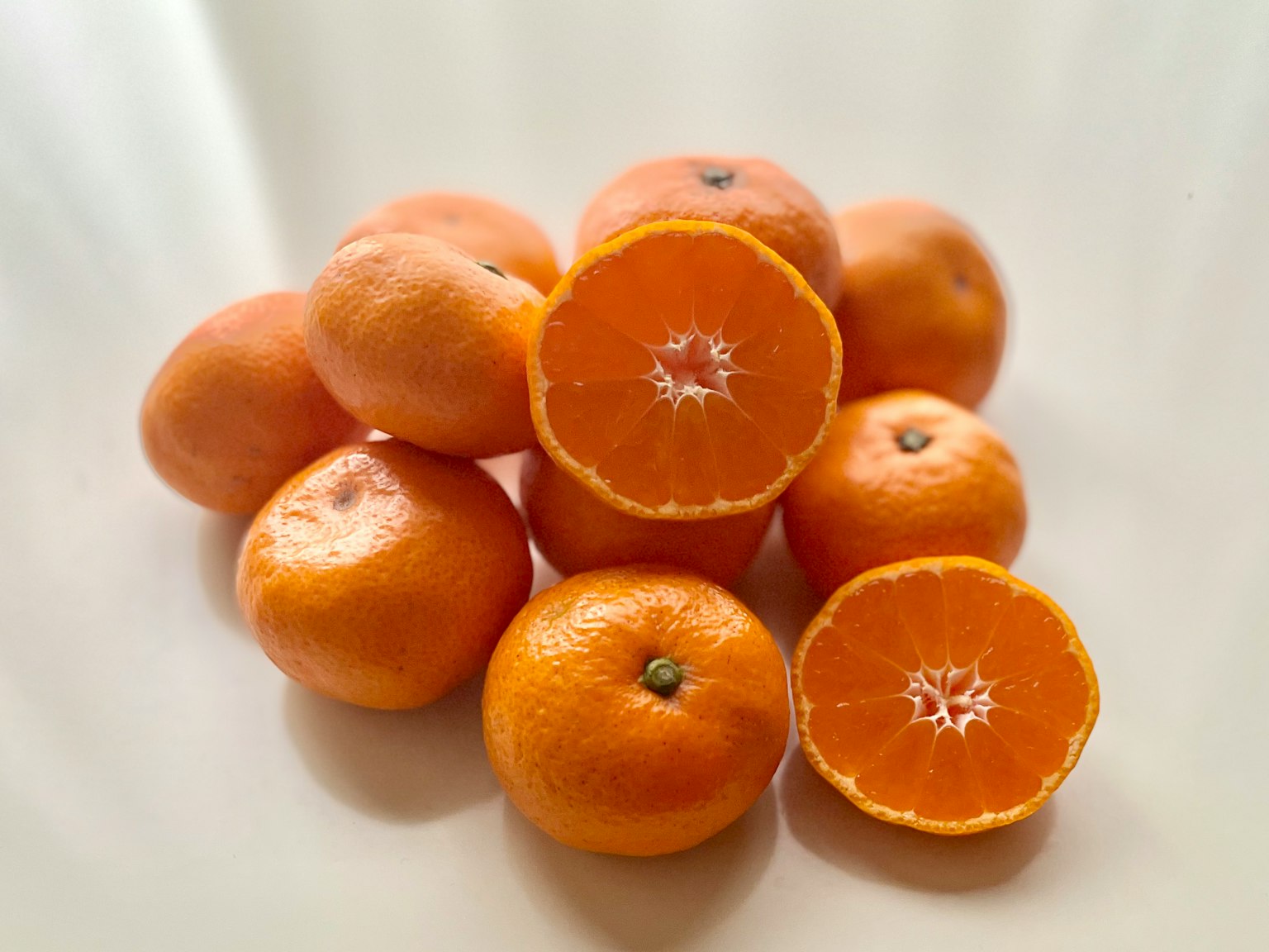 Ein Stapel frischer Orangen mit einer halbierten Orange