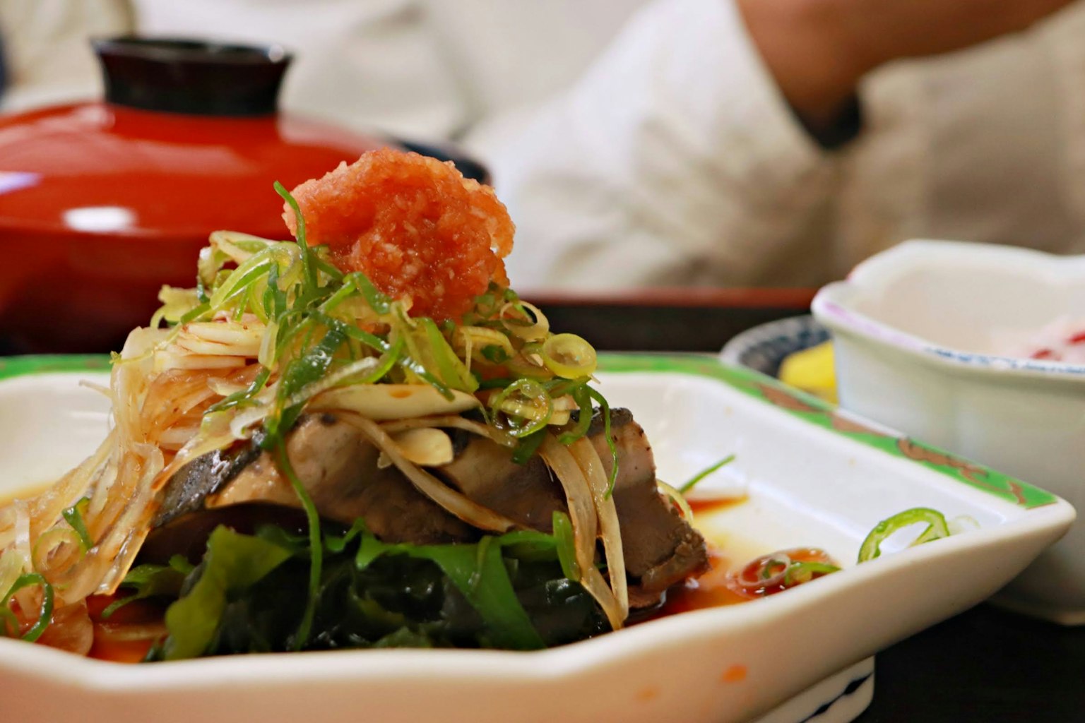 Une présentation vibrante de la cuisine japonaise avec du poisson frais et des légumes dans une assiette