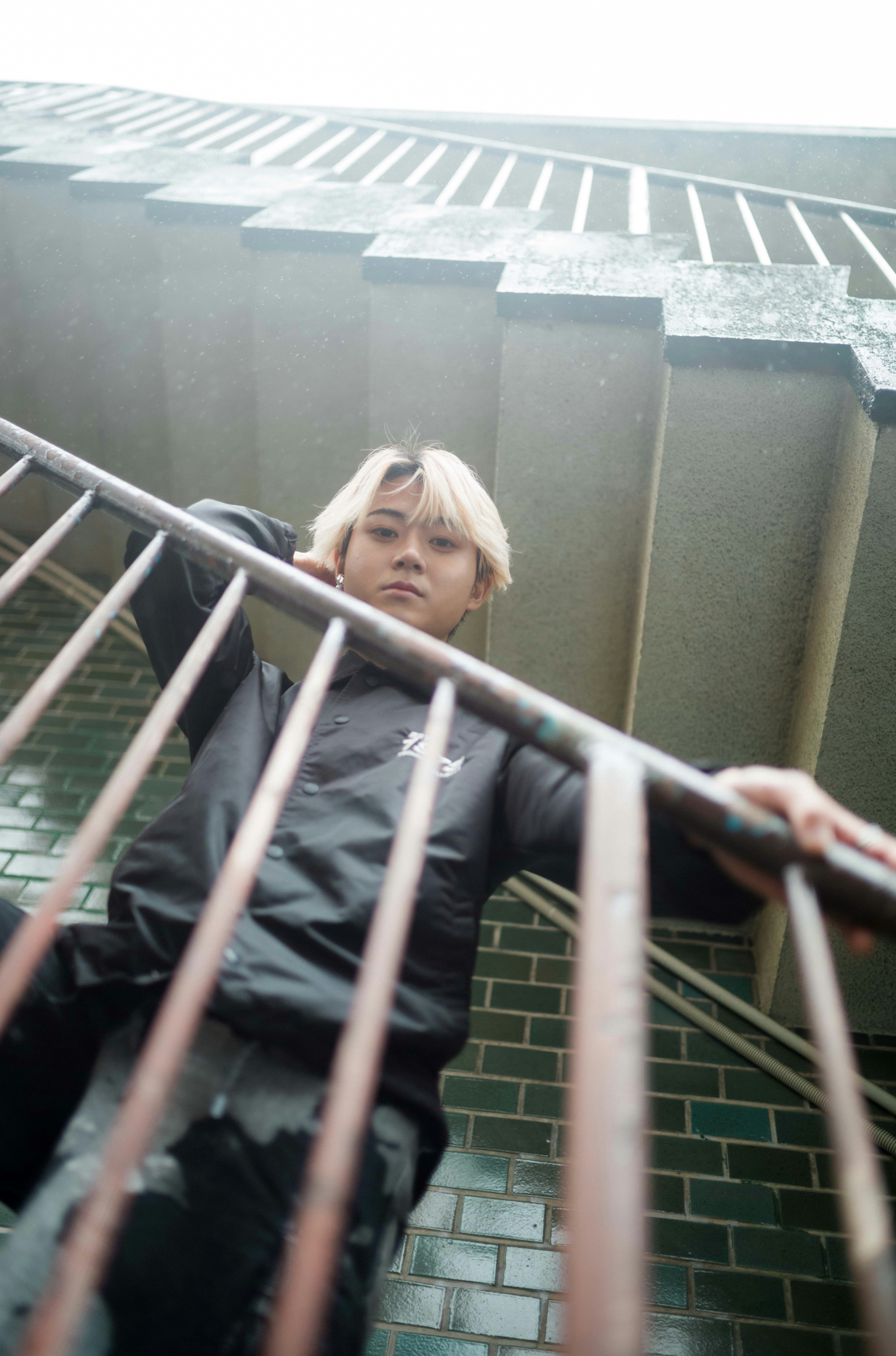 personne appuyée sur une rampe d’escalier sous la pluie