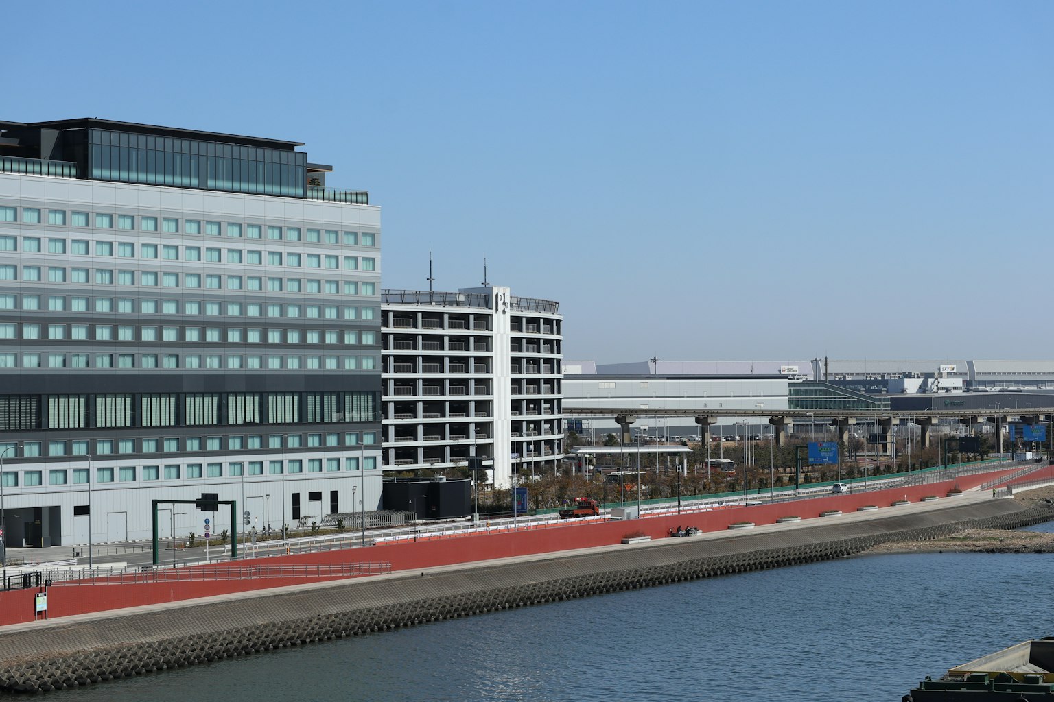 Modern buildings alongside a canal under a clear blue sky