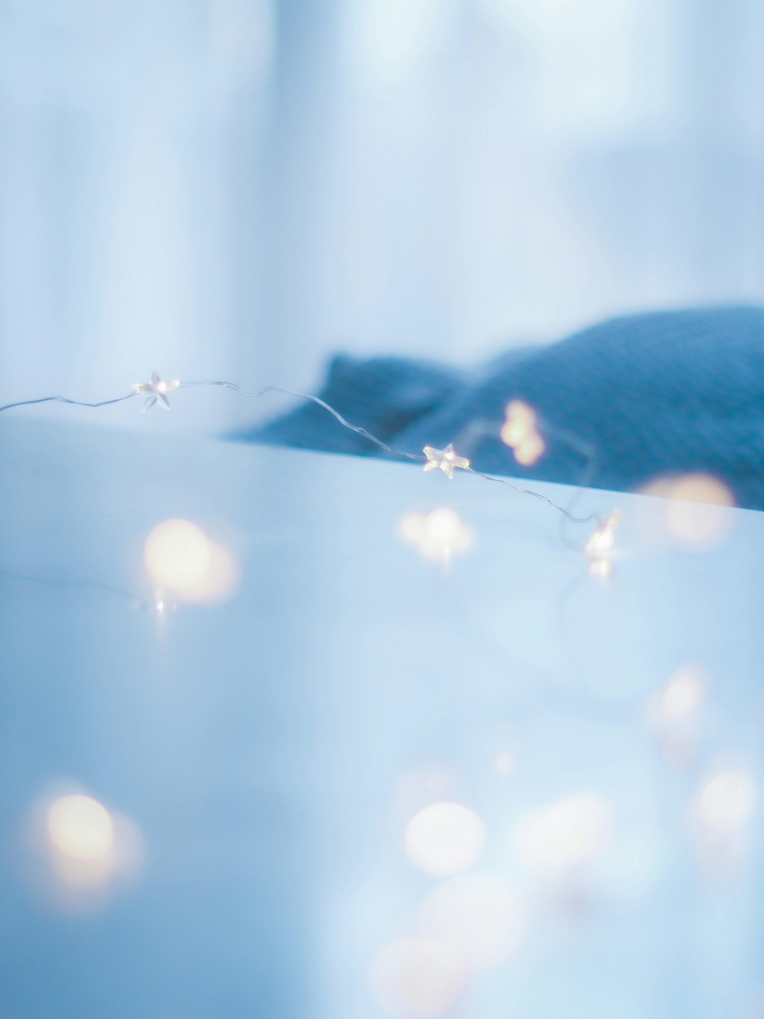 A photograph featuring soft glowing lights against a blue background