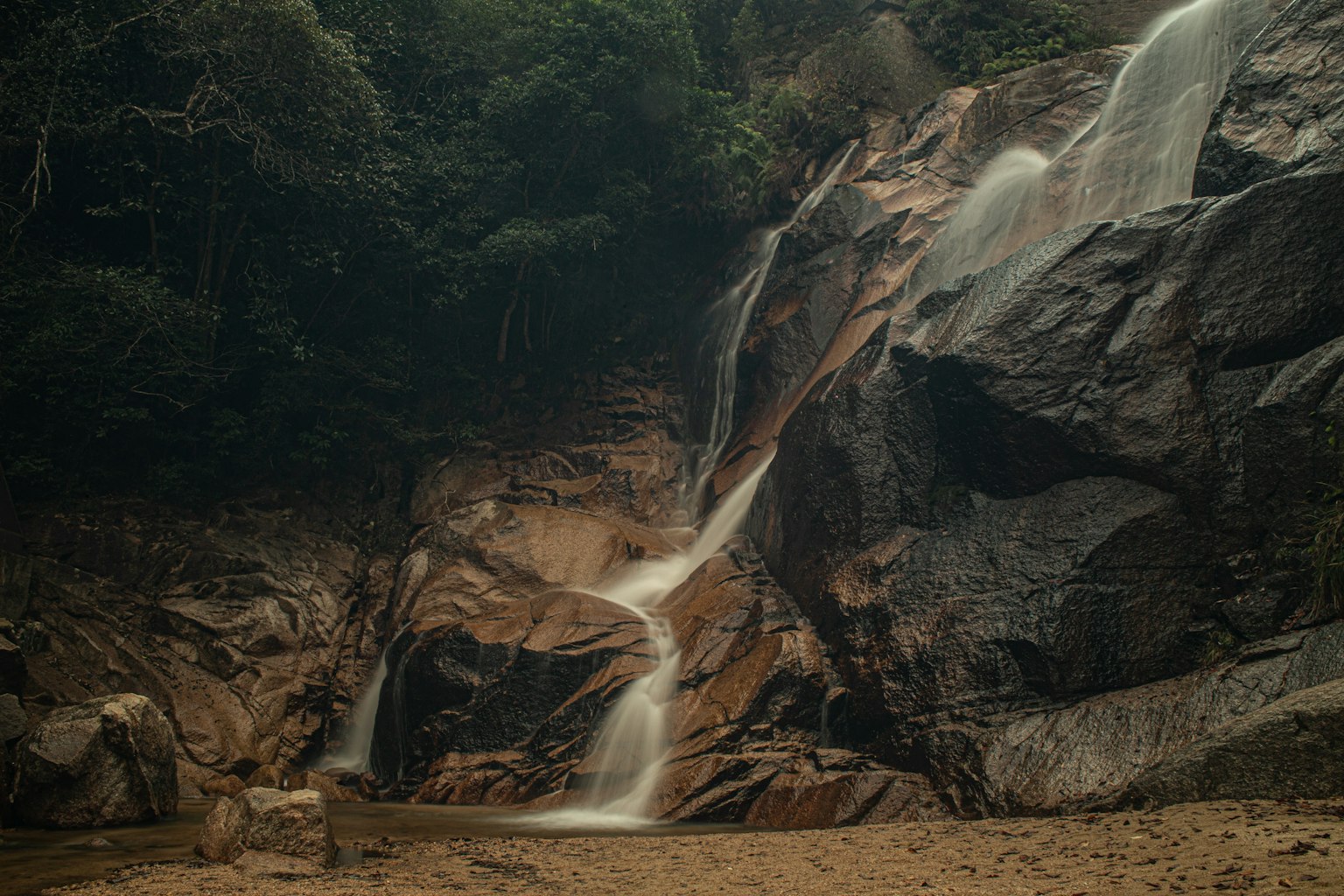 Una bella cascata che scorre su rocce circondate da verde lussureggiante