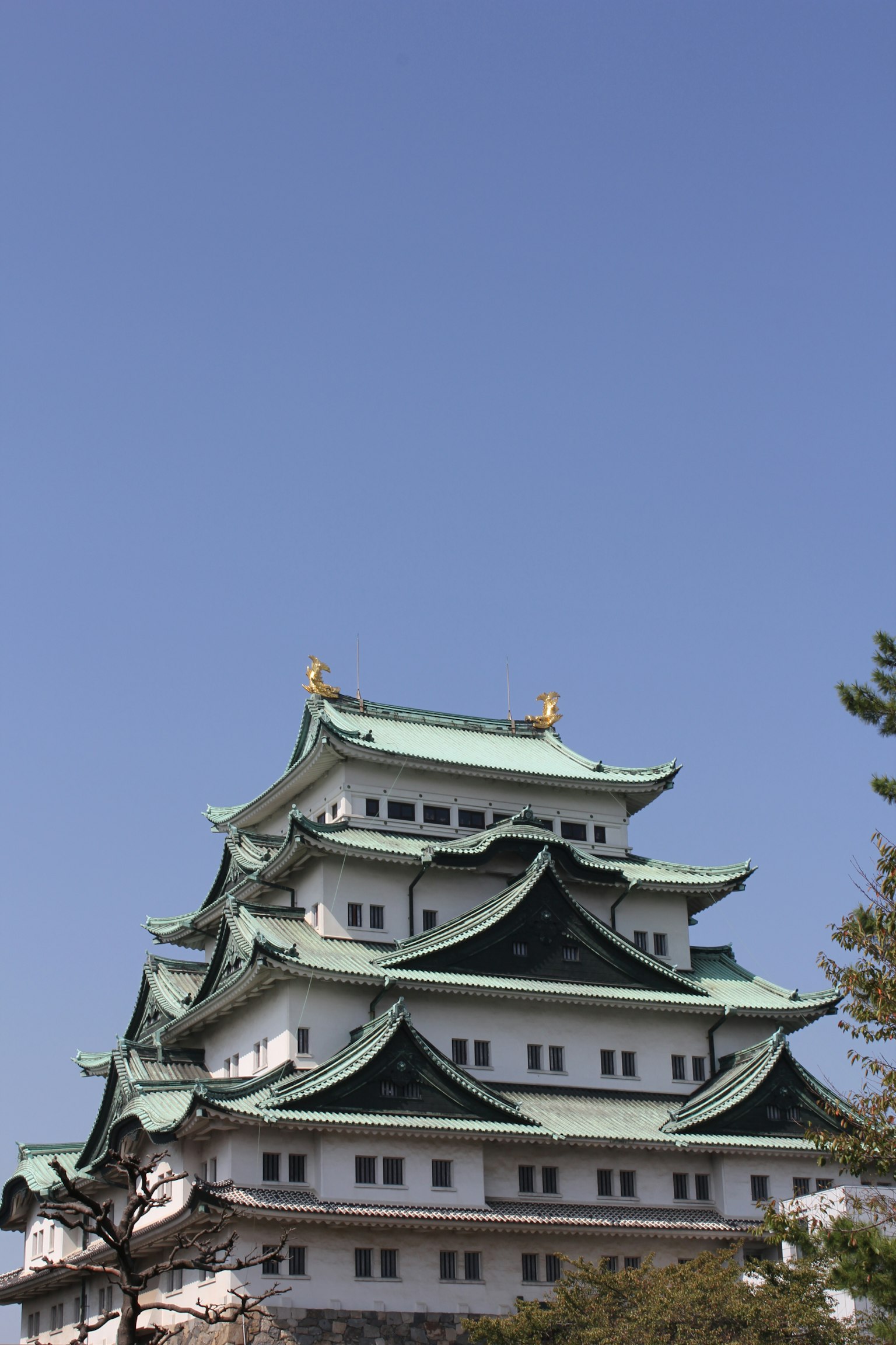 Nagoya Schloss mit grünen Dächern und blauem Himmel