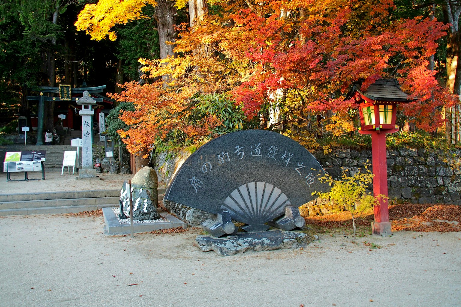Vue pittoresque avec un feuillage d'automne vibrant et une sculpture de éventail en pierre