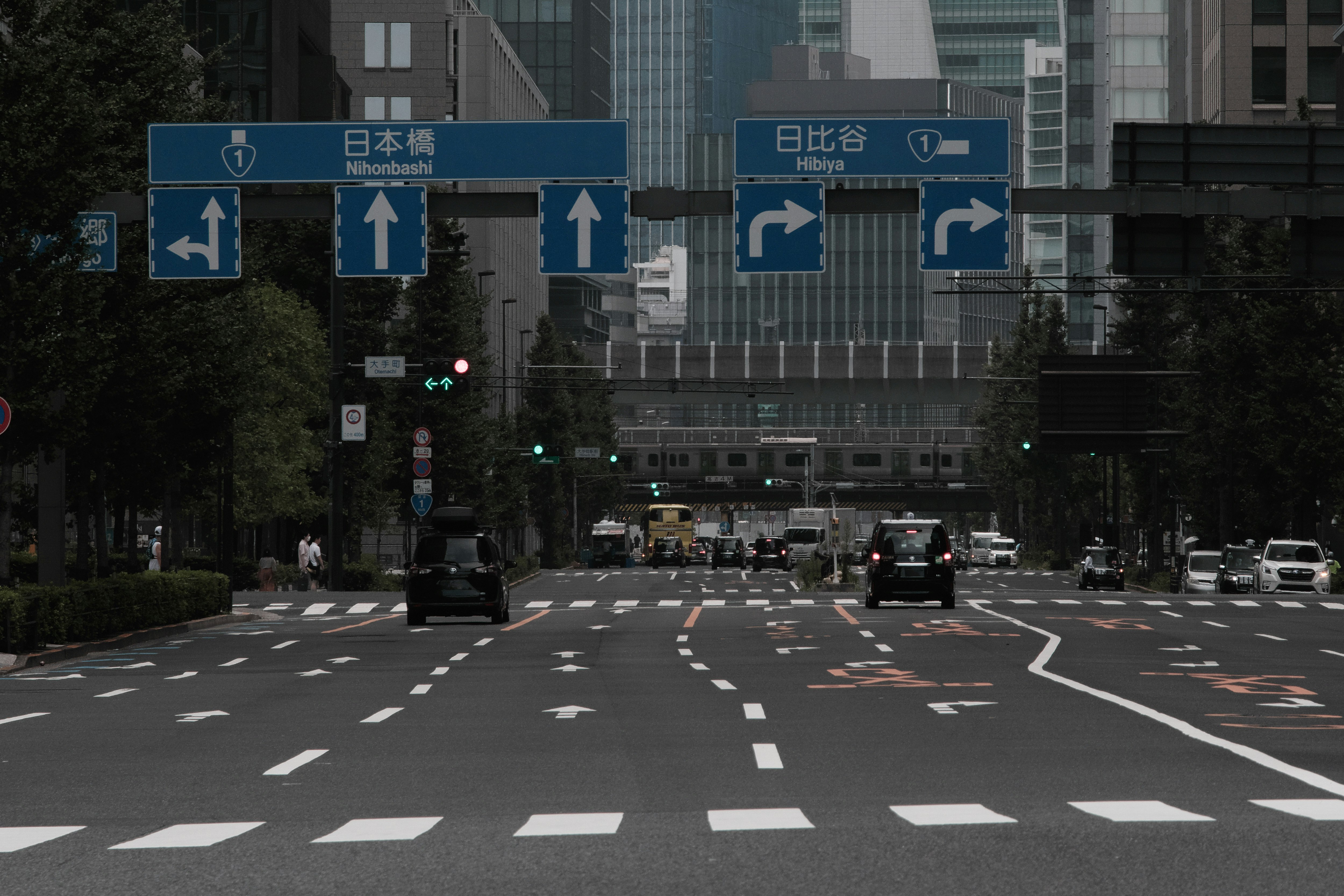 大手町の国道1号線を走る車と交差点の標識が見える都心の街並み