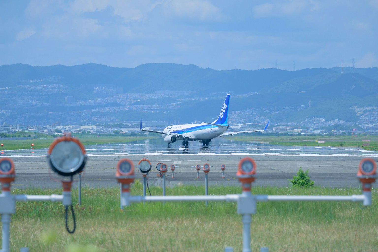 Avión aterrizando en la pista con cielo azul de fondo y marcadores de pista