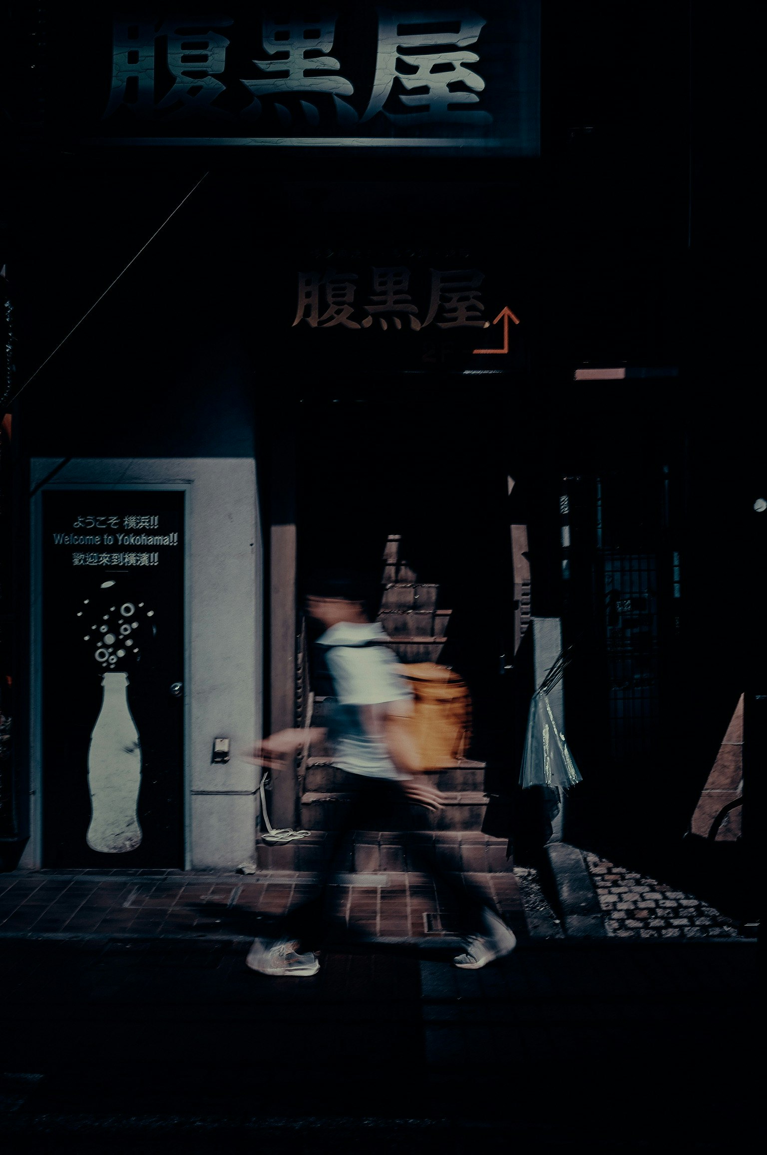 nighttime storefront alley with illuminated Chinese sign