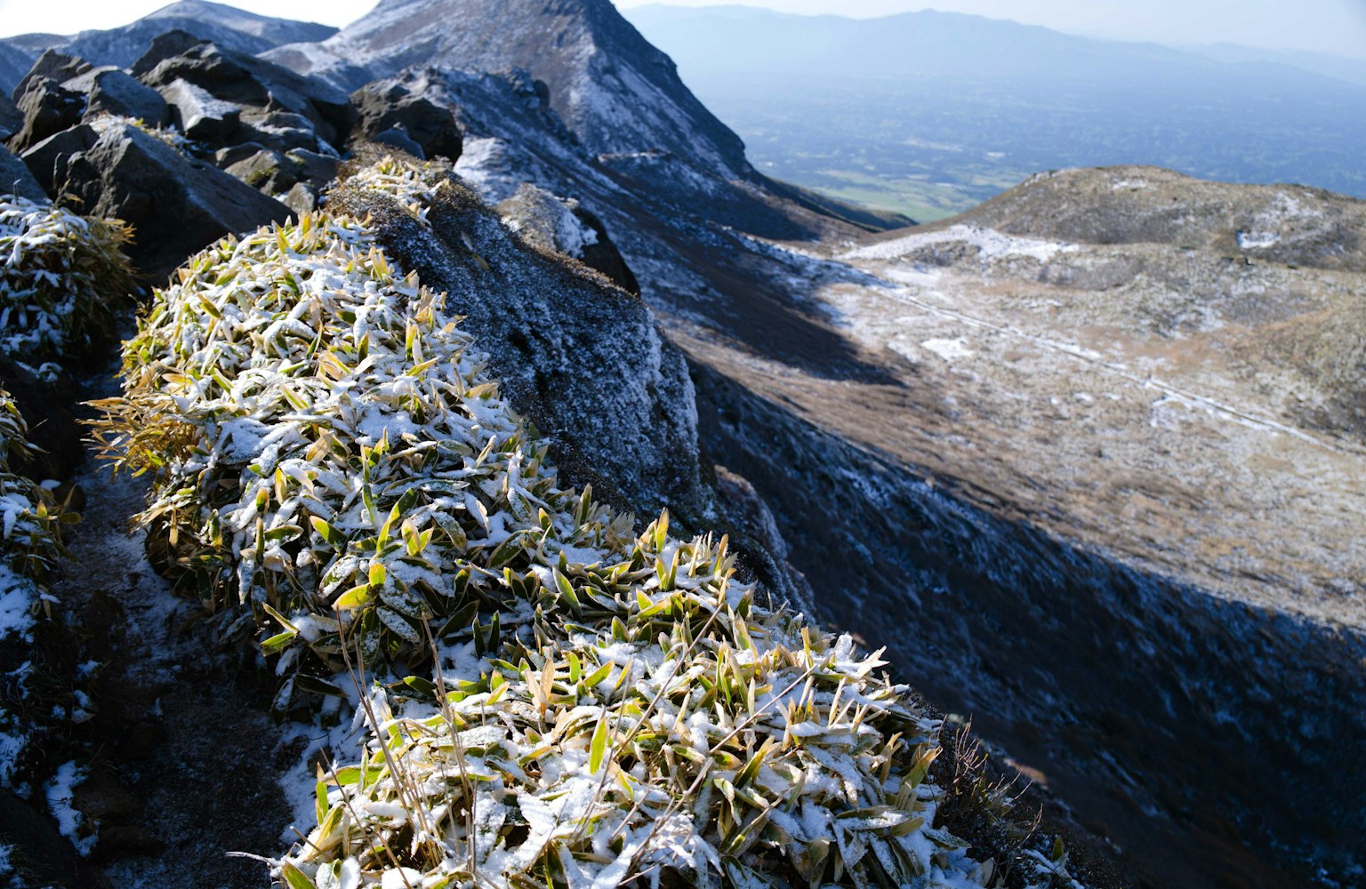 Snow-covered mountain grass and rocky landscape