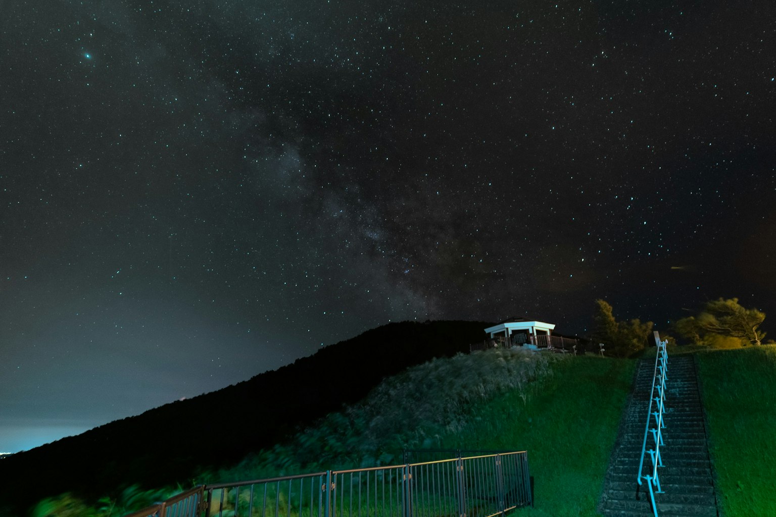 Schöne Nachtszene mit einem Hügel und Treppen unter dem Sternenhimmel