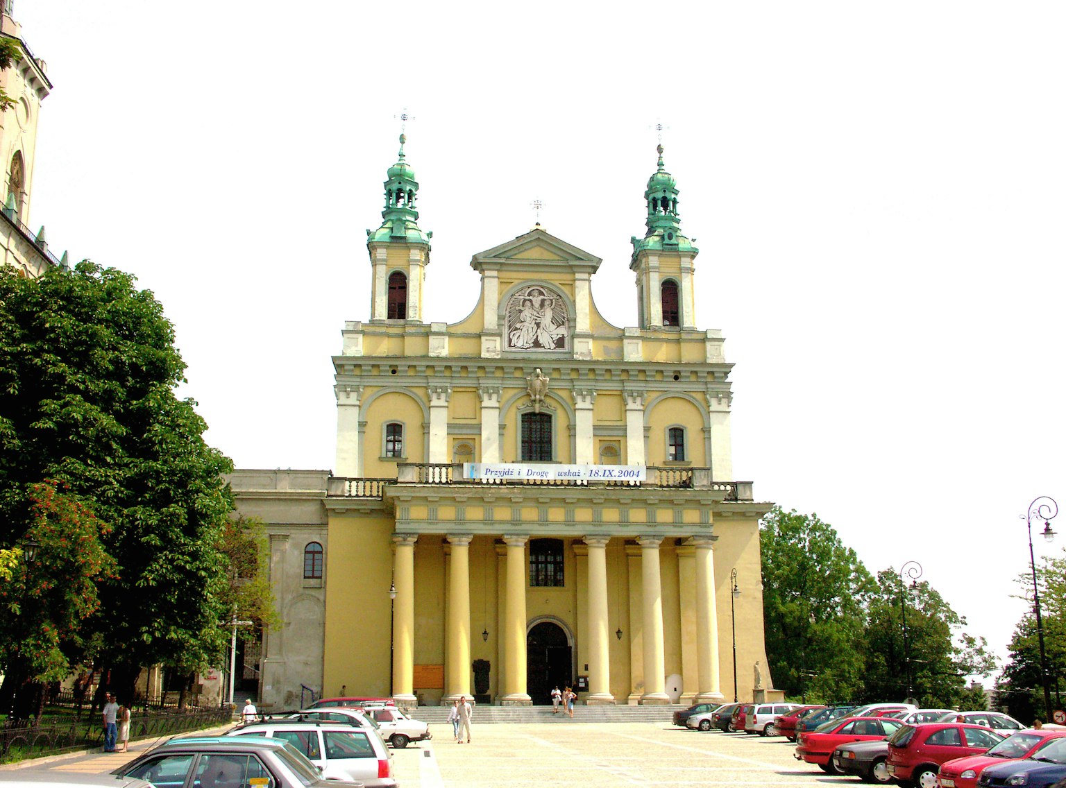 Façade d'une église historique avec des flèches vertes et des colonnes hautes