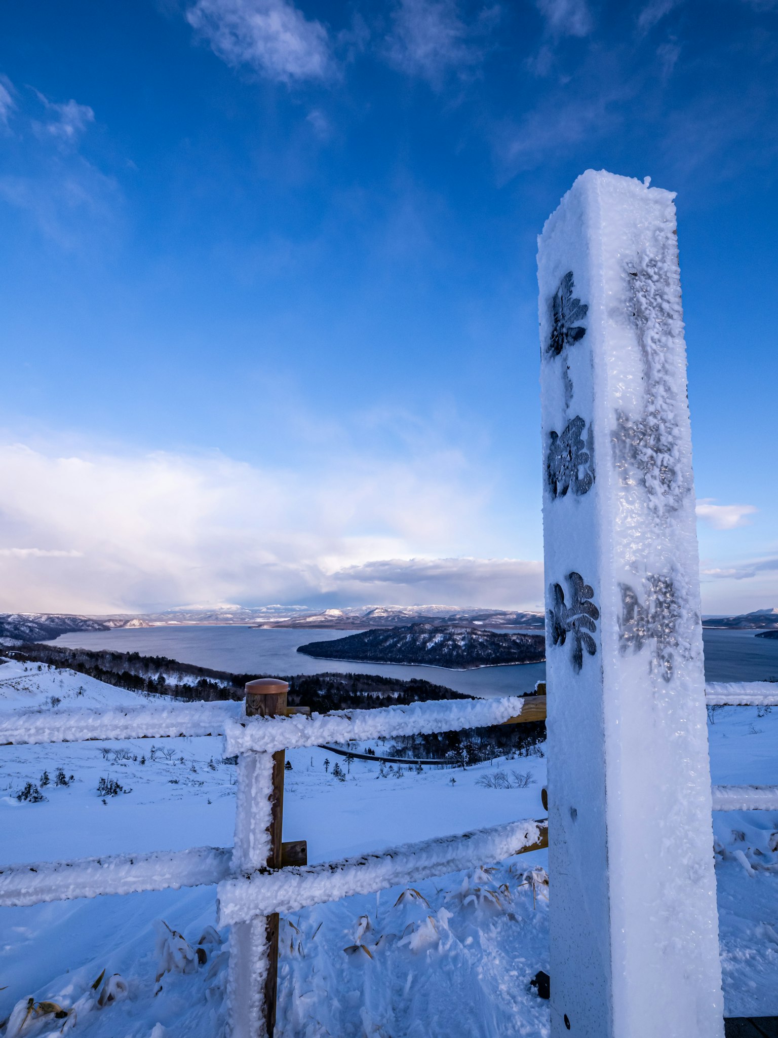 Snow-covered landscape with a signpost under a blue sky