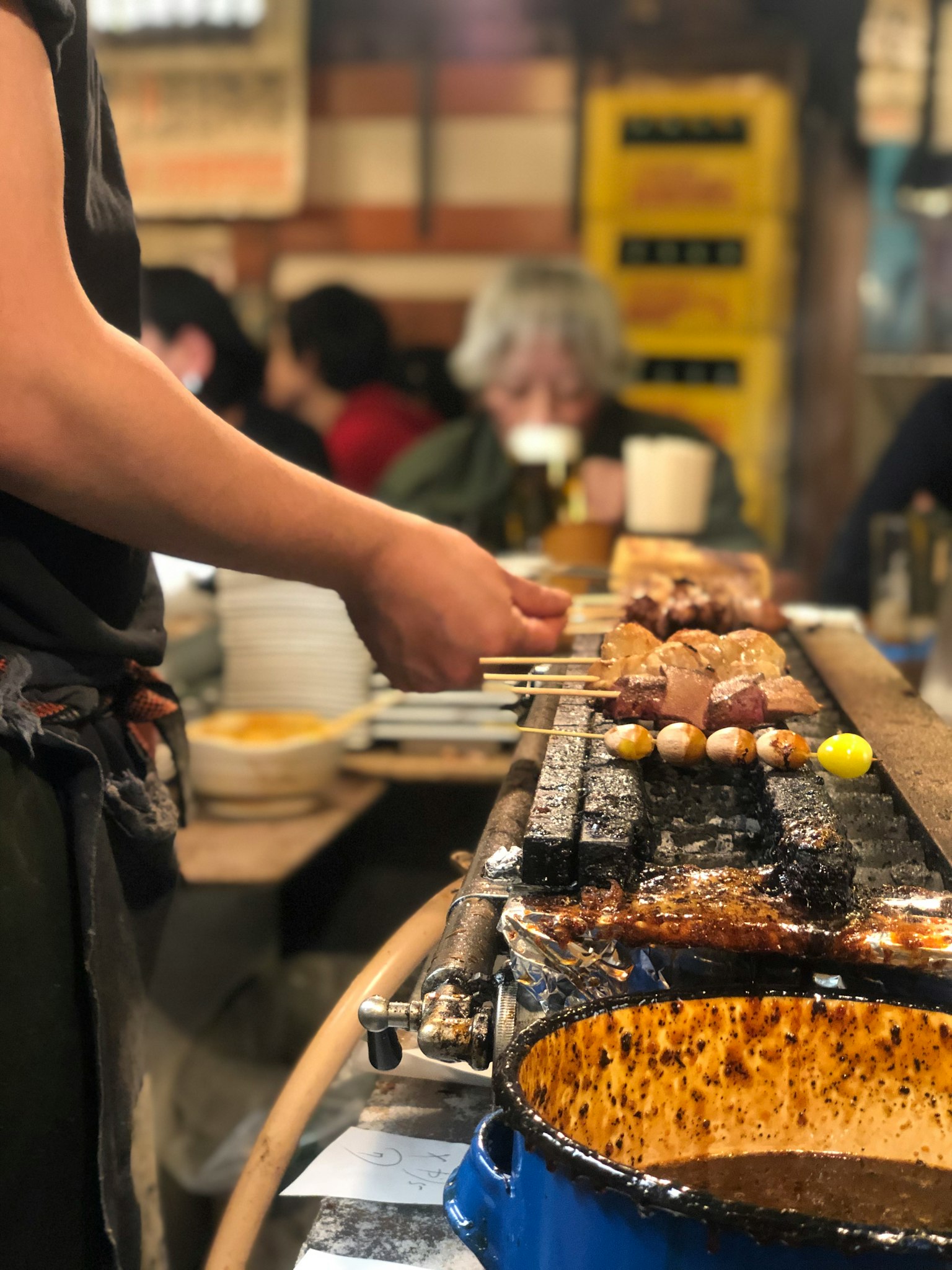 廚師在熱鬧的餐廳中用串烤製燒鳥