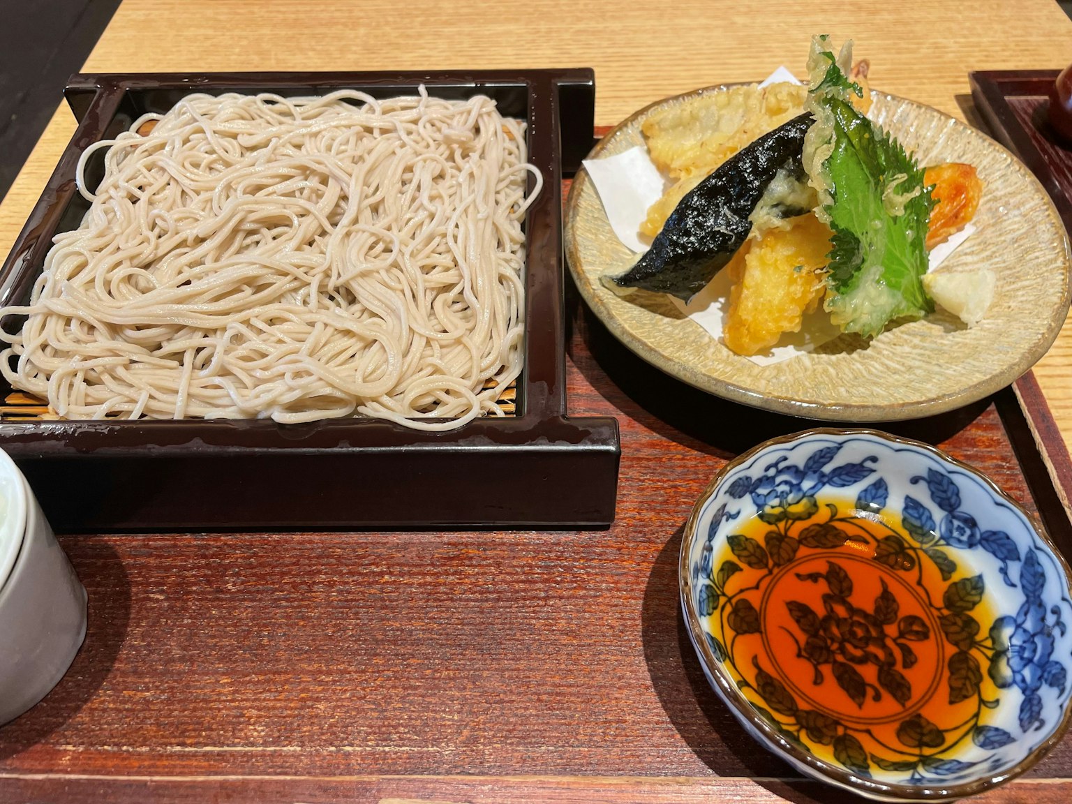 Soba-Nudeln serviert mit Tempura und Dip-Sauce