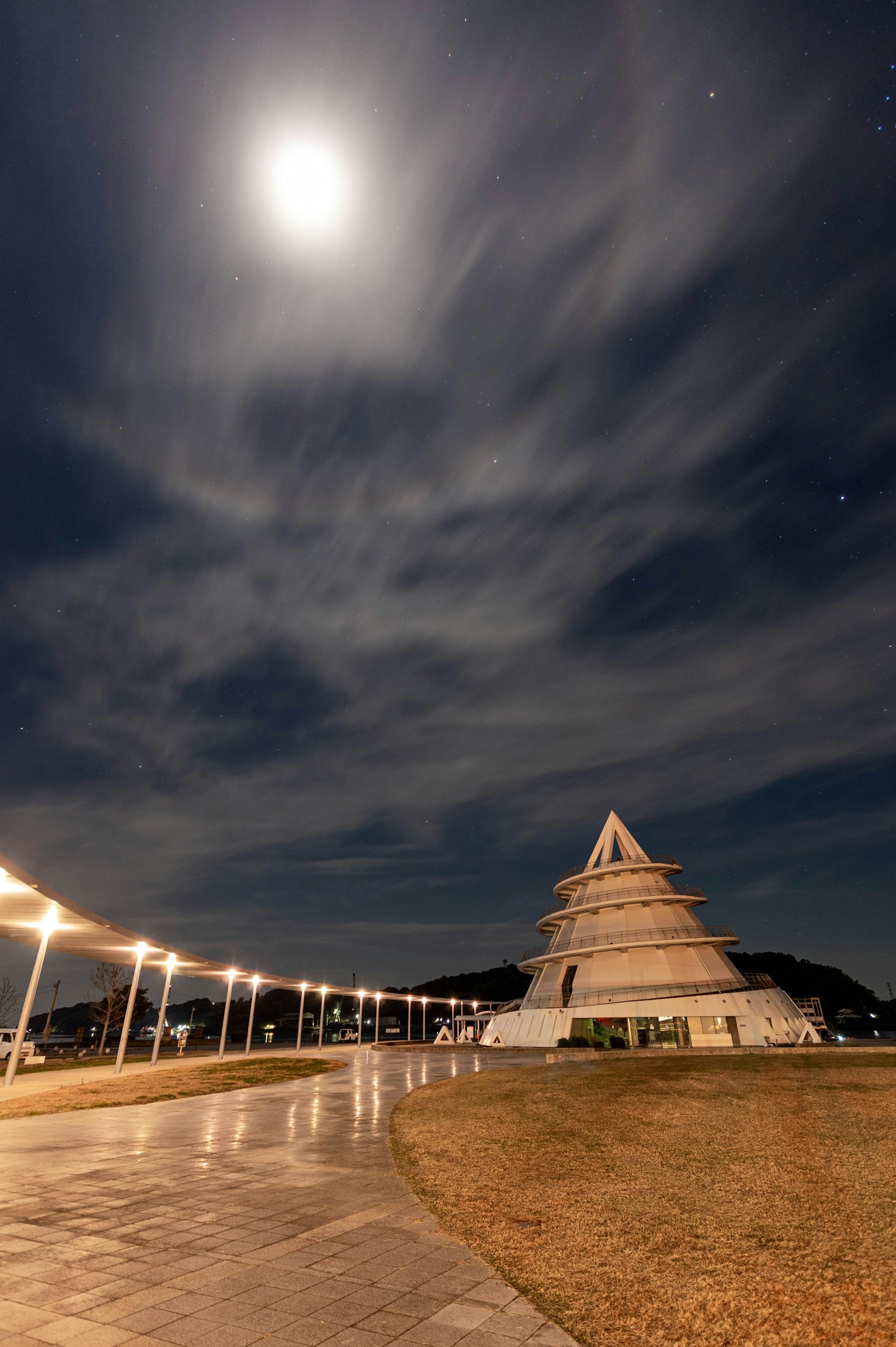 Scena notturna con un edificio a forma di piramide sotto una luna brillante