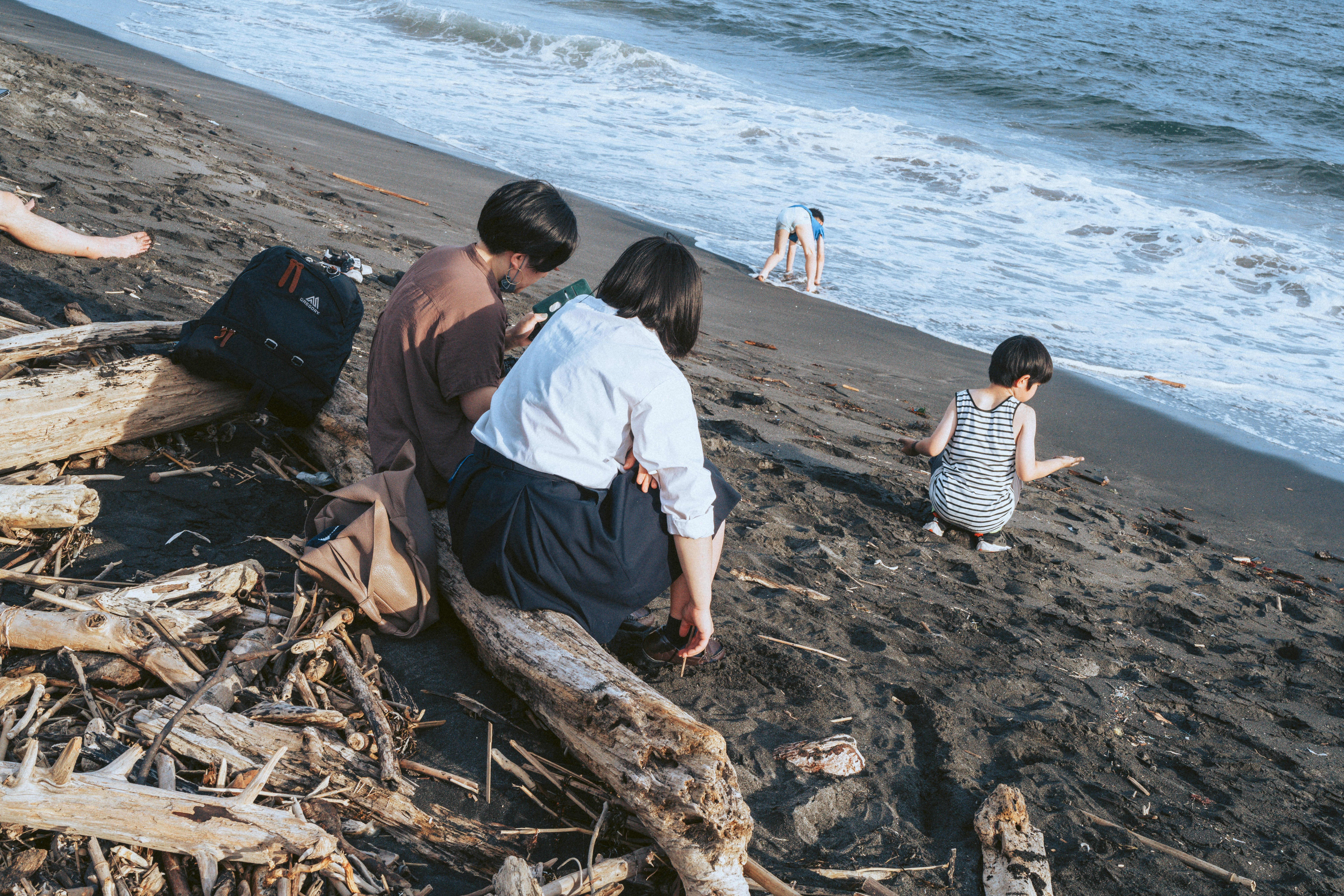 family playing near driftwood on a beach
