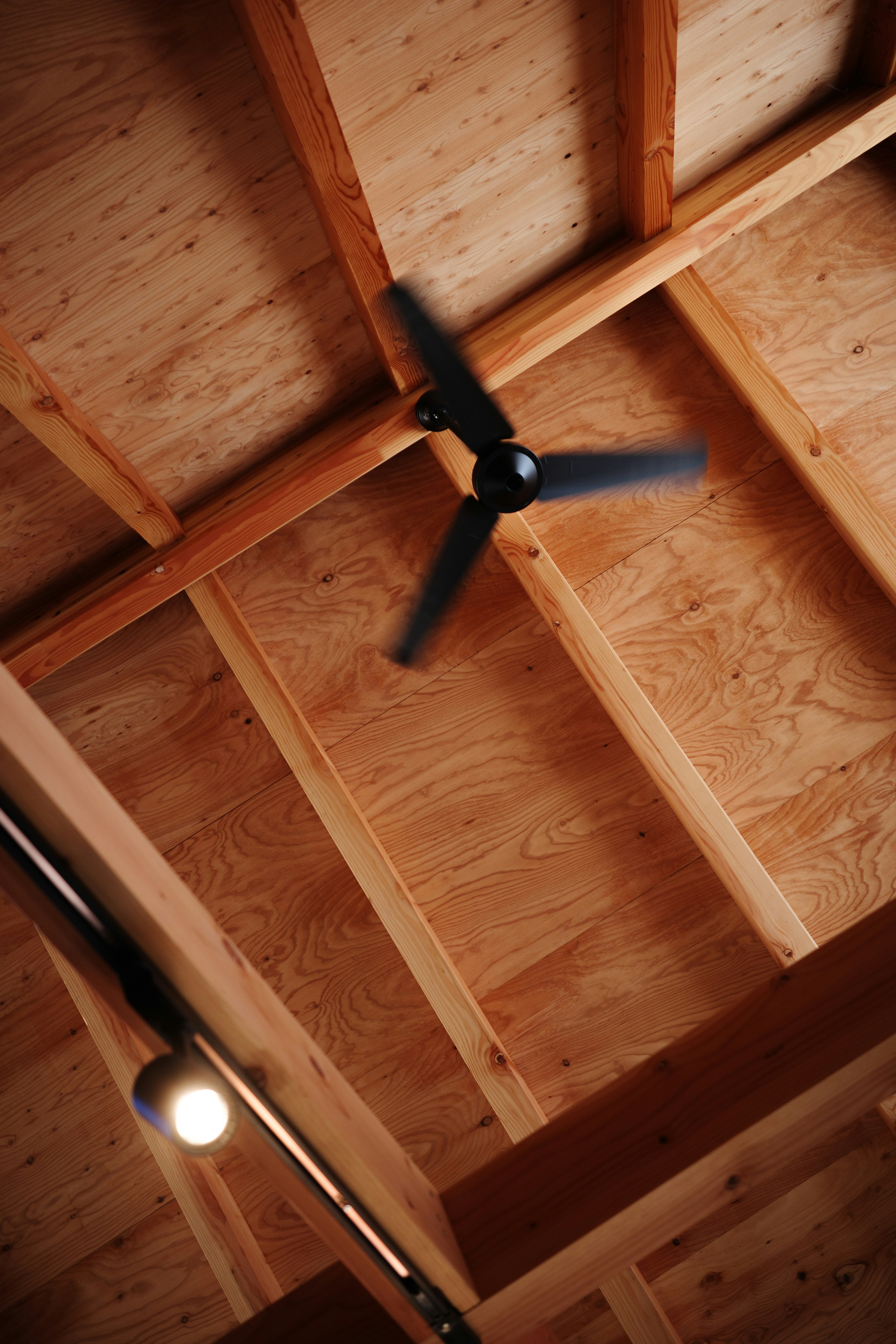 wooden ceiling beams with a ceiling fan inside