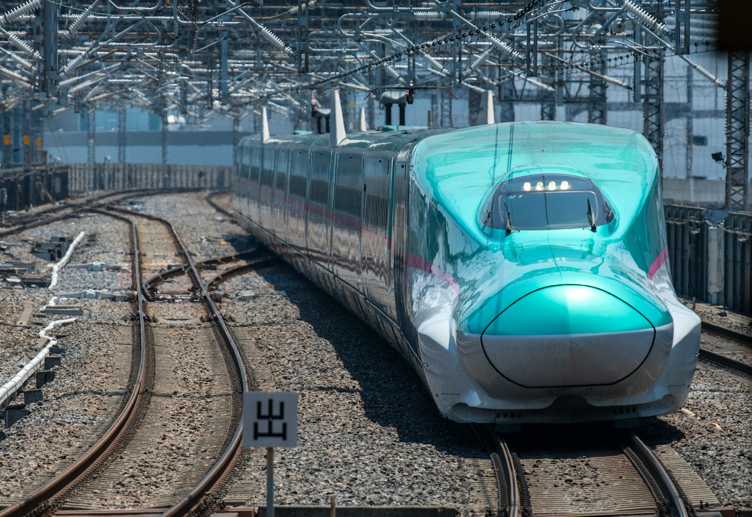 青綠色的新幹線列車在彎曲的軌道上行駛
