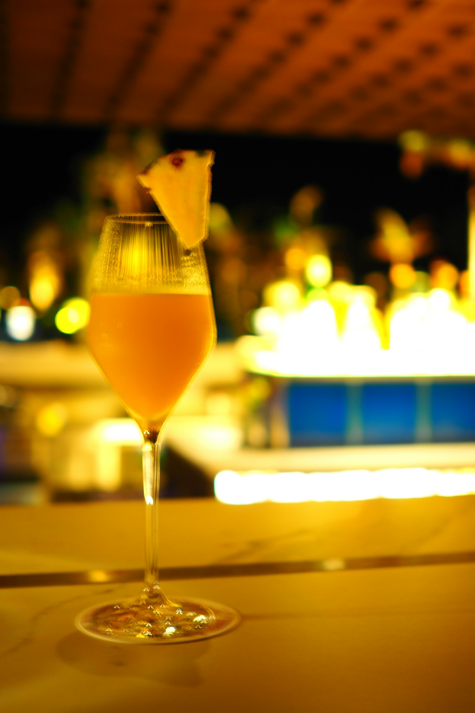 Cocktail arancione in un bicchiere con guarnizione di ananas