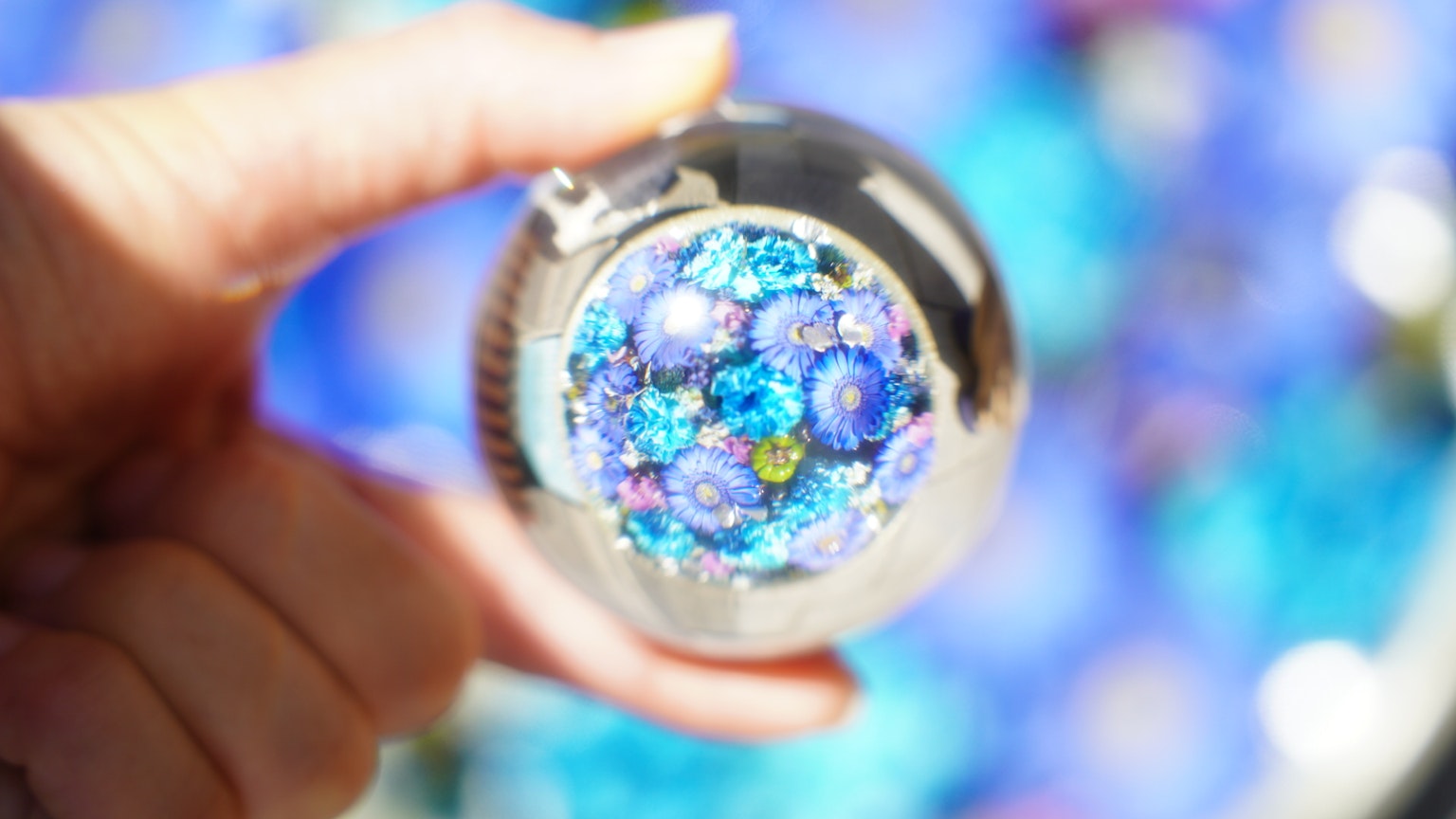 Một món đồ trang trí với họa tiết hoa màu xanh đang được cầm trên tay