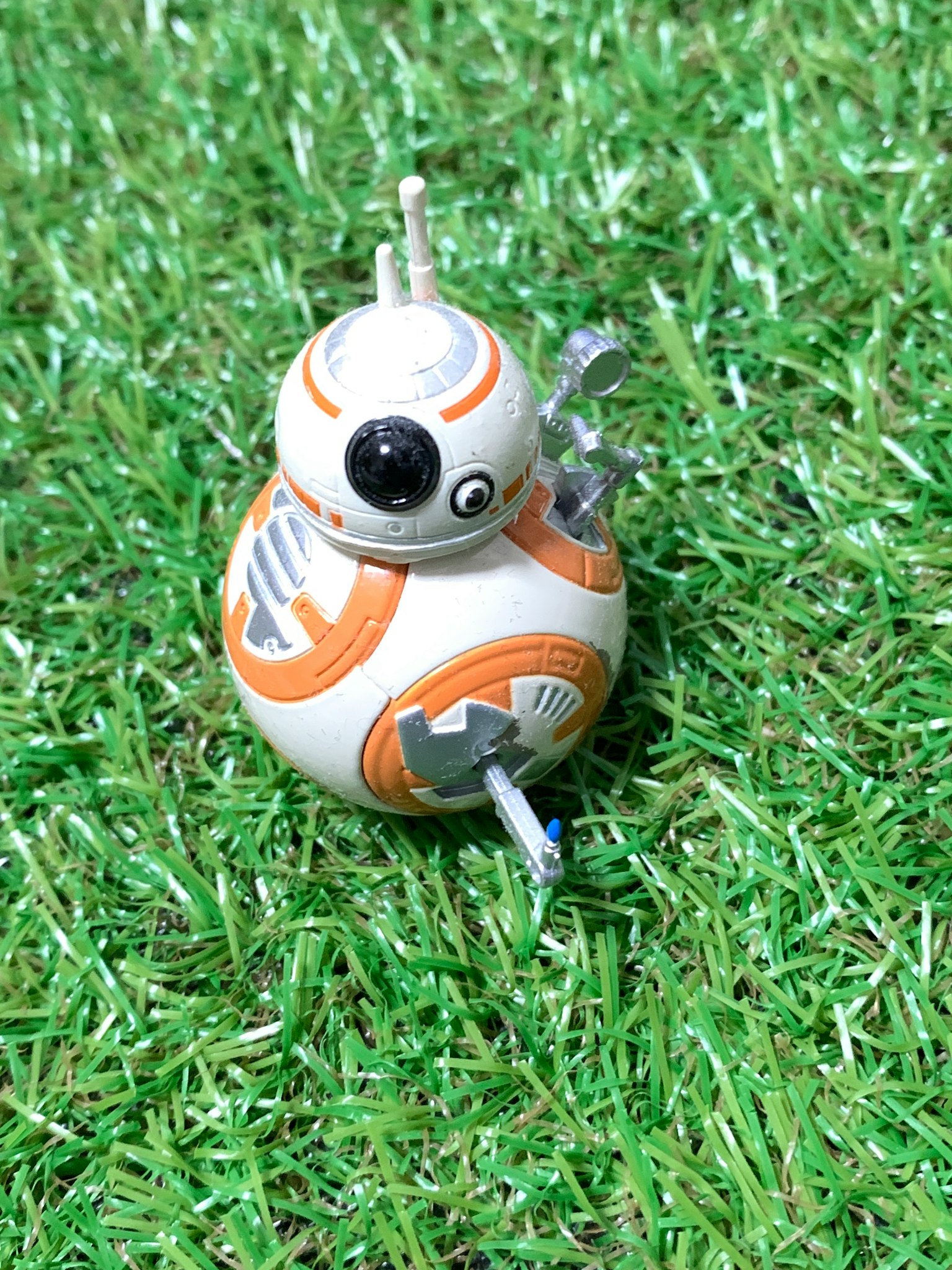 BB-8 로봇이 녹색 인조 잔디 위에 놓여 있습니다