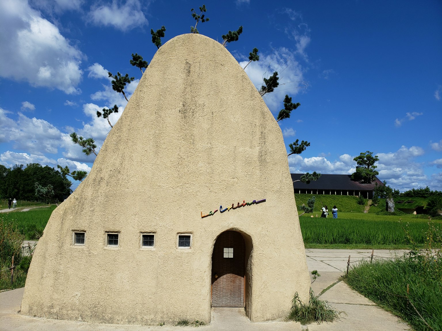 Bâtiment unique en forme dans la nature avec des plantes poussant sur le dessus