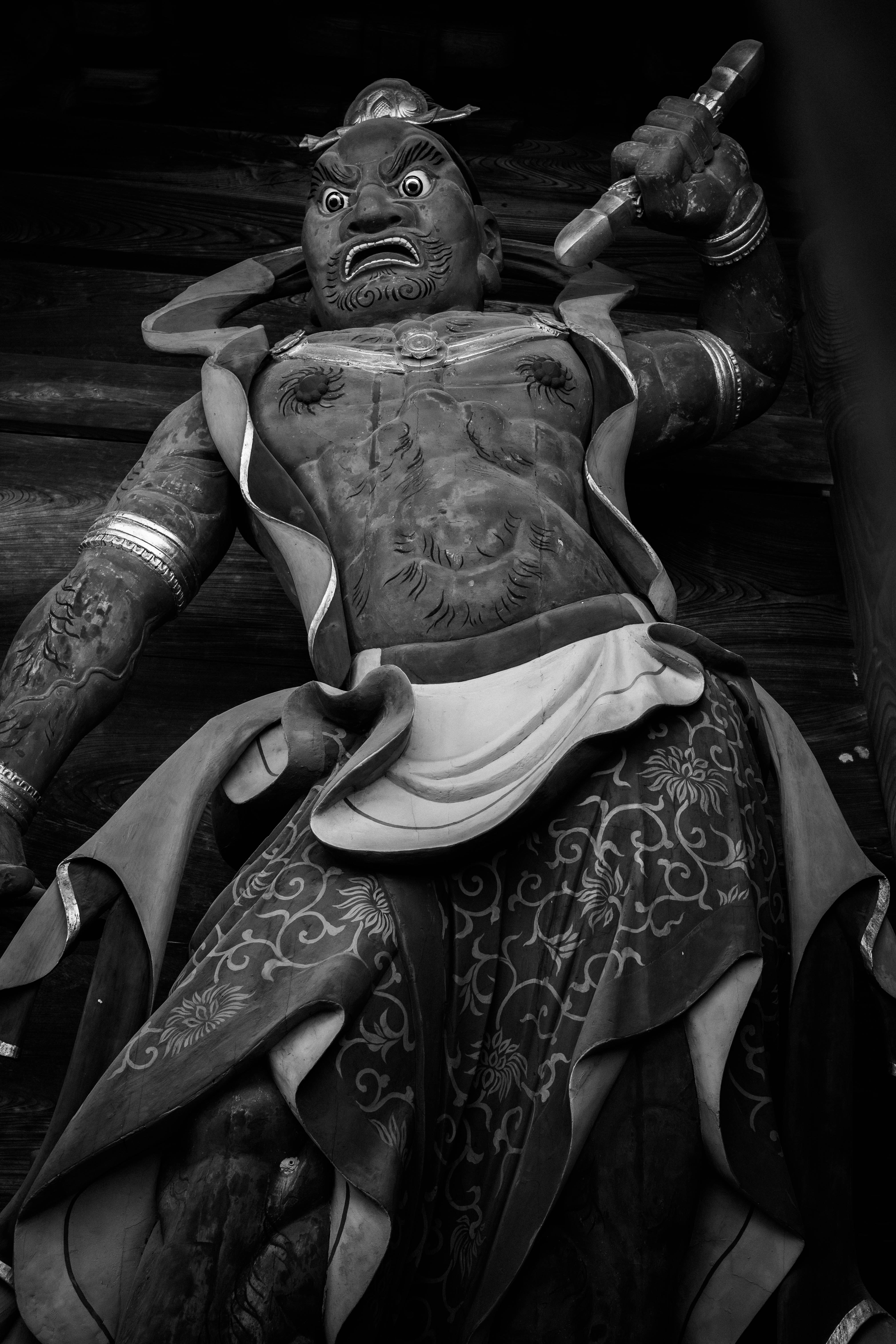creepy doll-like character holding a musical instrument on a dark street