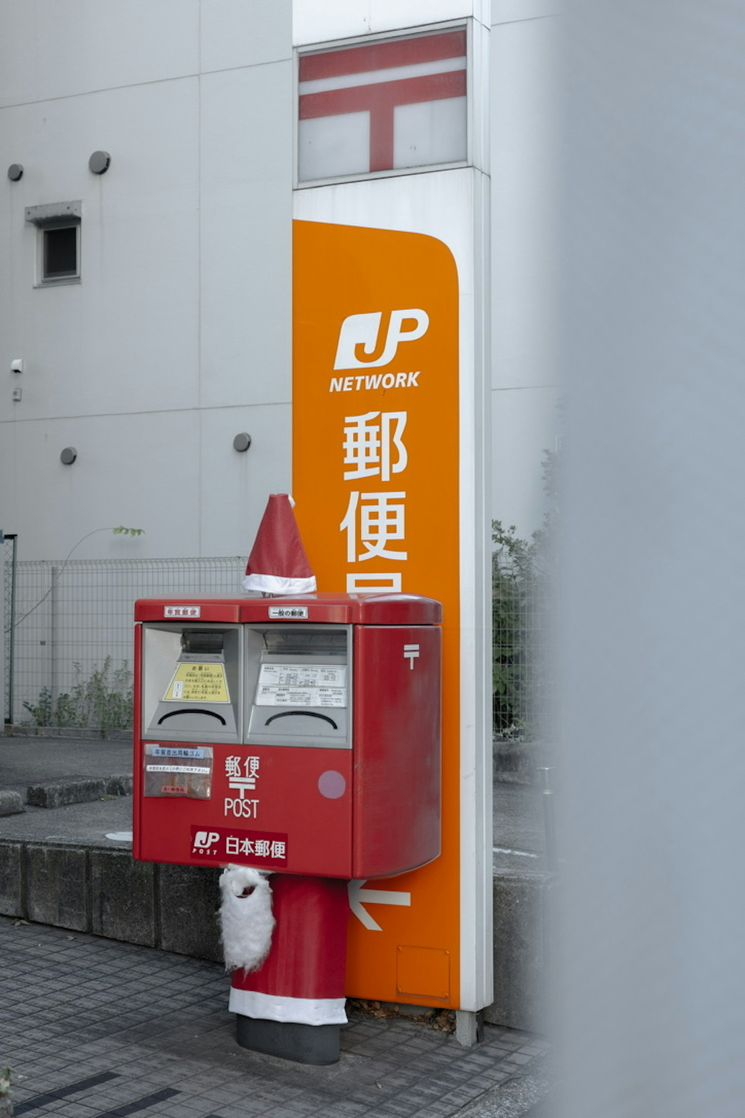 Cassetta postale rossa con insegna arancione JP Network