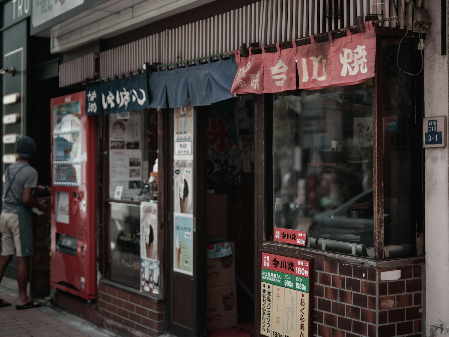 Eksterior sebuah restoran Jepang kecil dengan menu yang ditampilkan di jendela