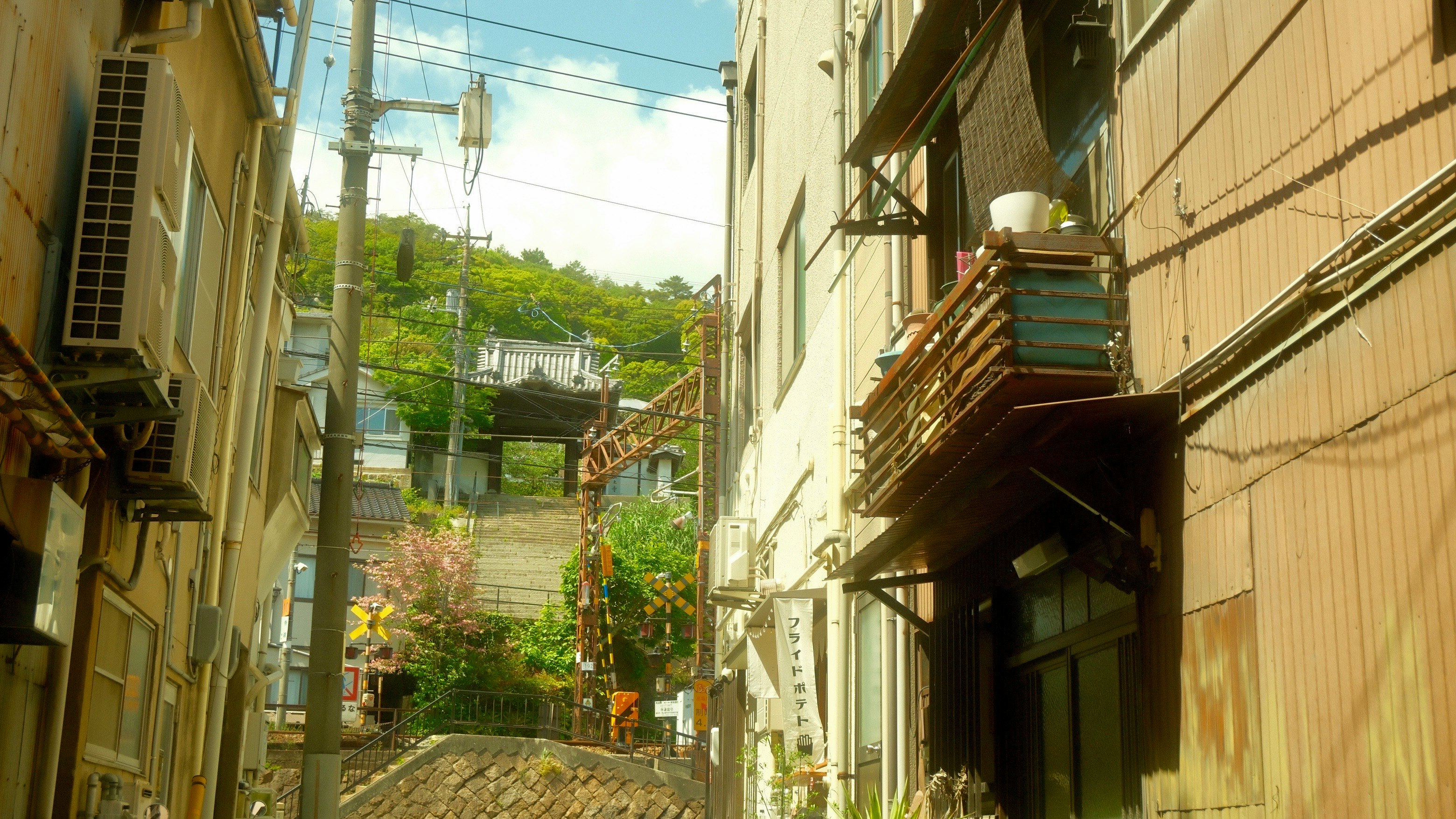路地に面した建物の外壁と階段のある街並み