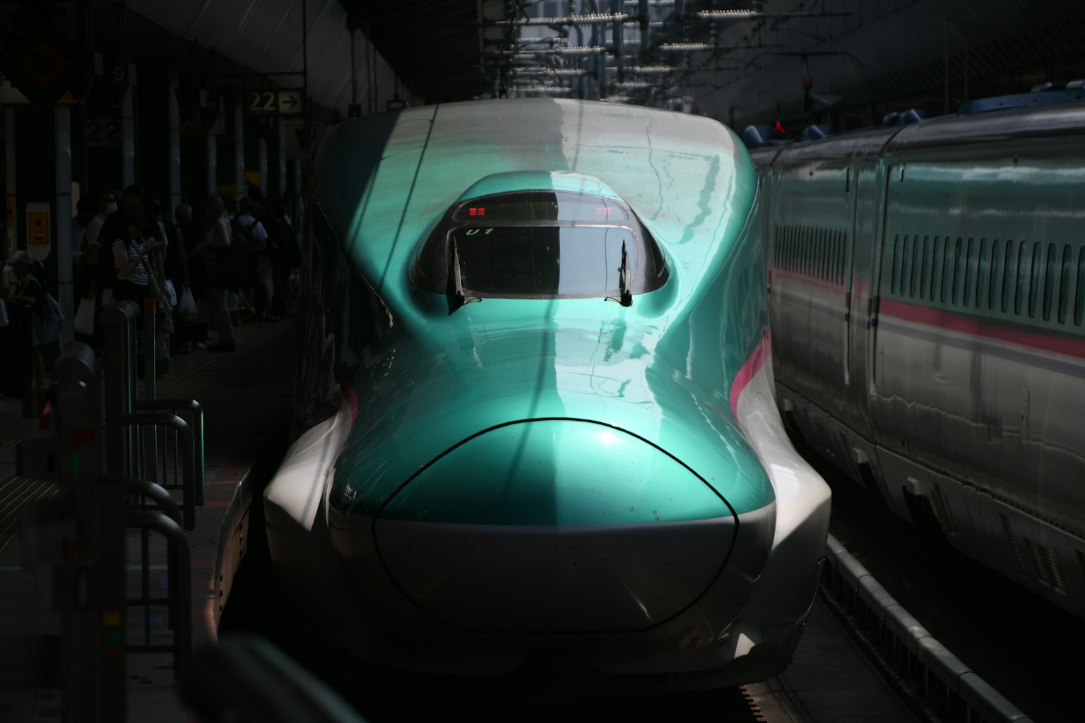 一列獨特的綠色新幹線列車在車站停靠，設計流線型