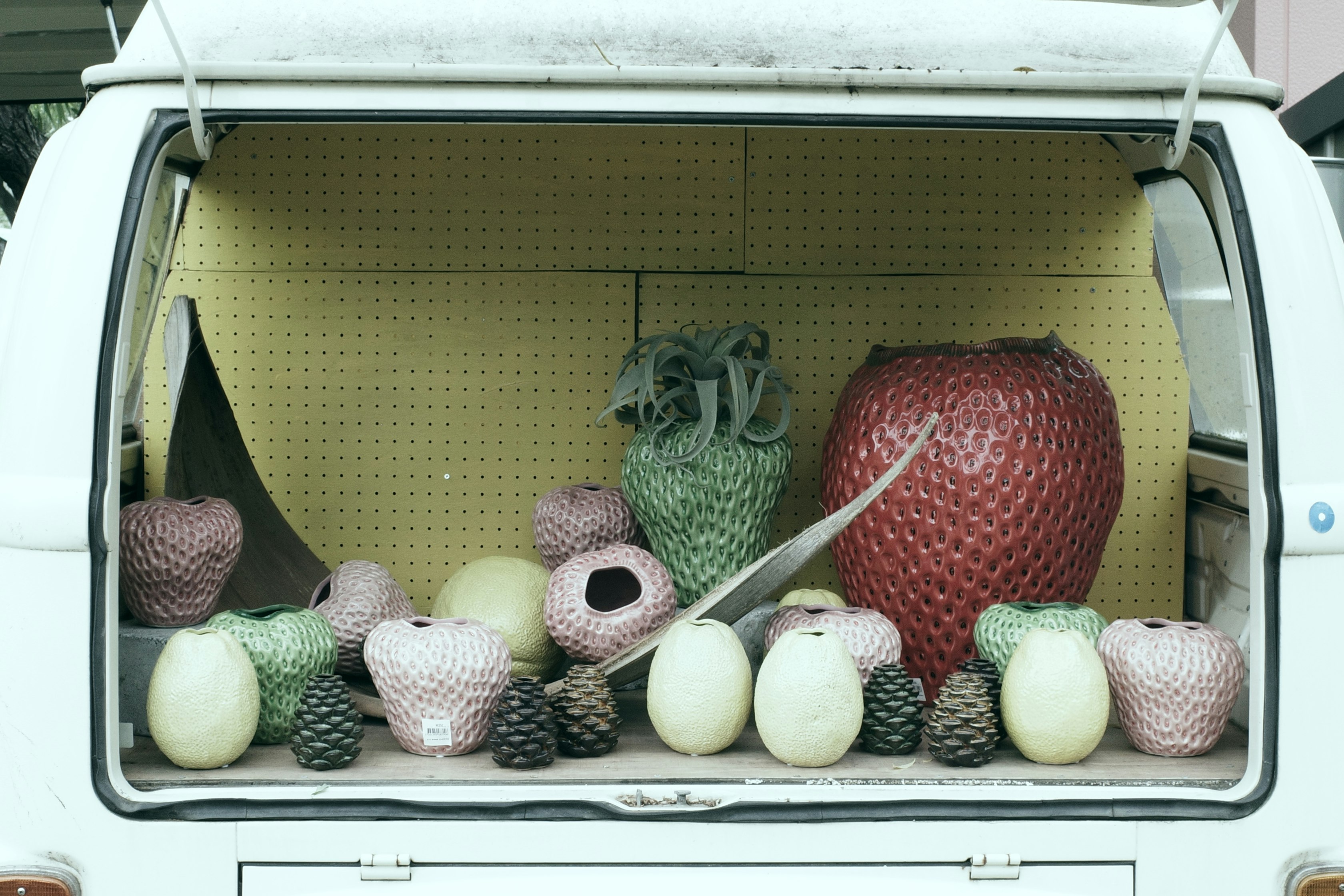A white refrigerator drawer filled with crocheted plush and spherical objects