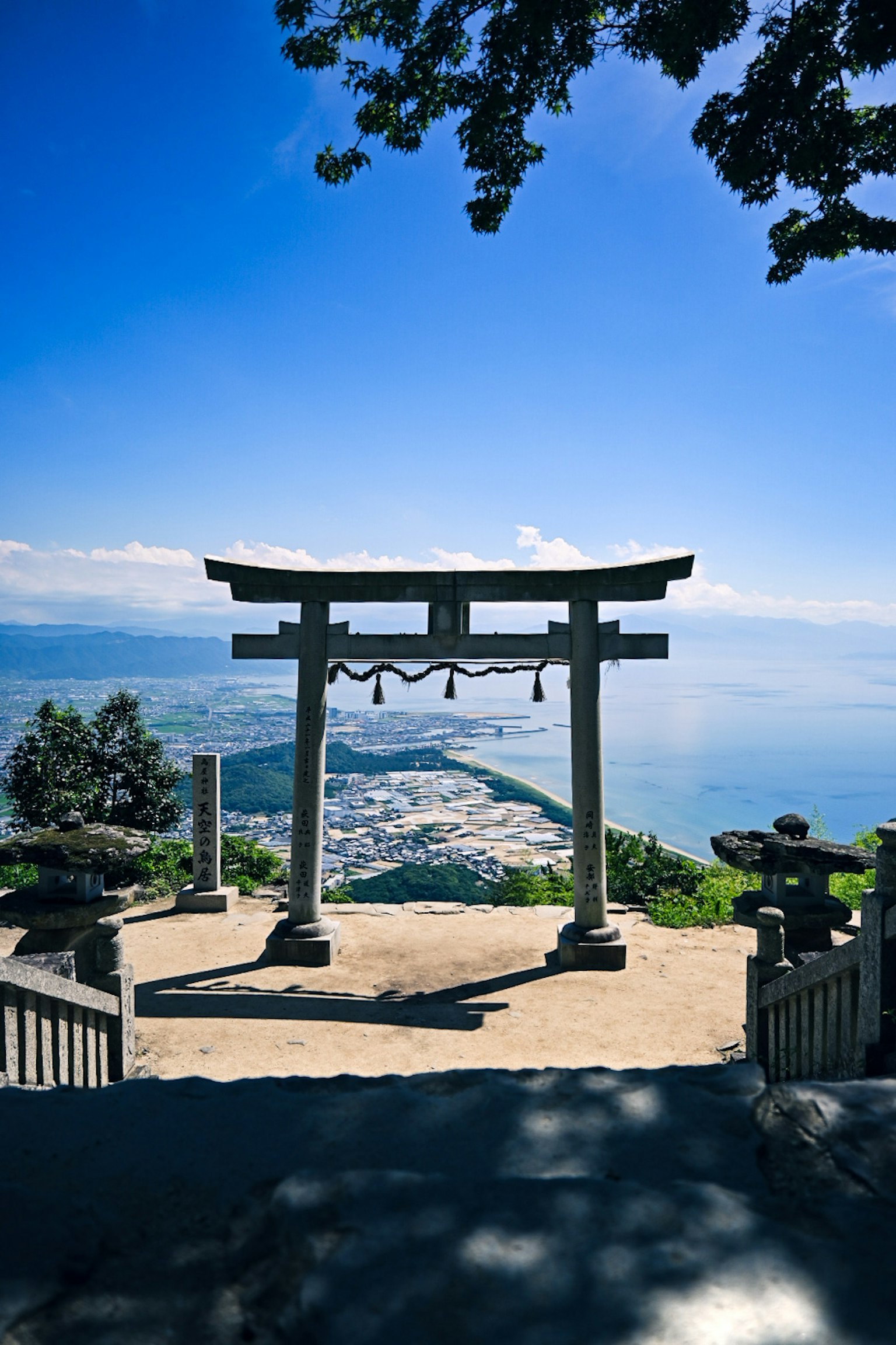 Torii surplombant une belle vue sur la mer avec des lanternes en pierre