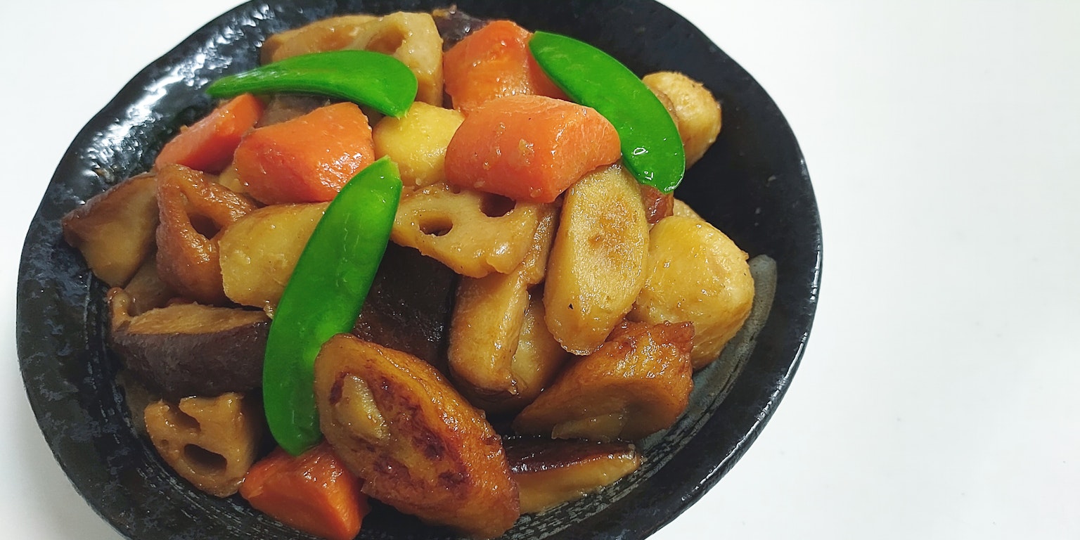 黑碗中盛着的多彩莲藕和蔬菜菜肴
