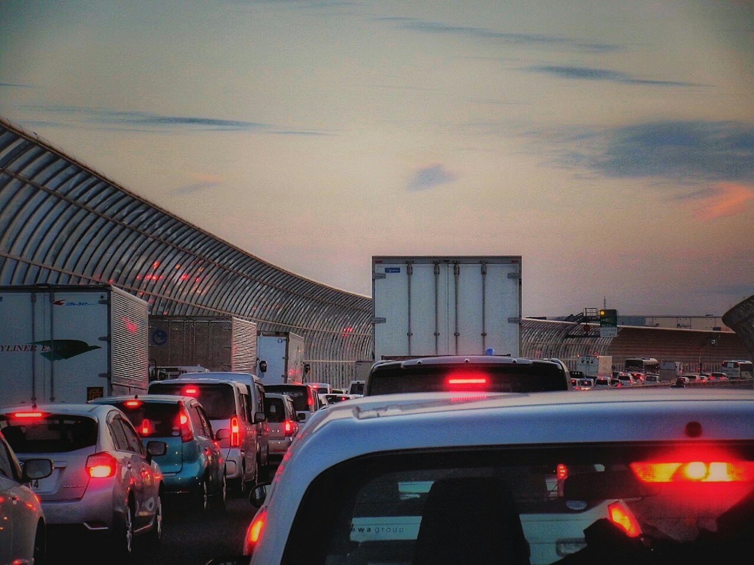 Stau in der Dämmerung mit Fahrzeugen und Lastwagen in Reihe