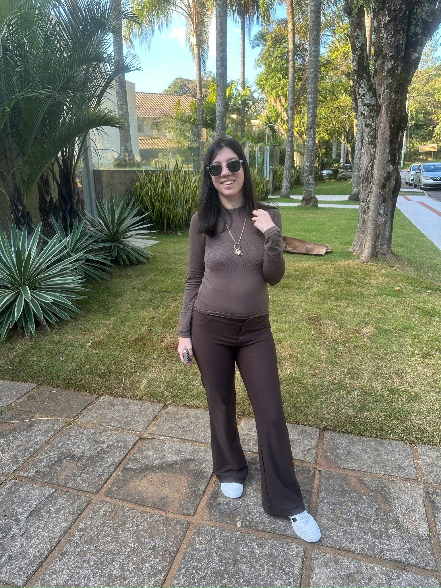 donna in posa in un giardino con prato e palme