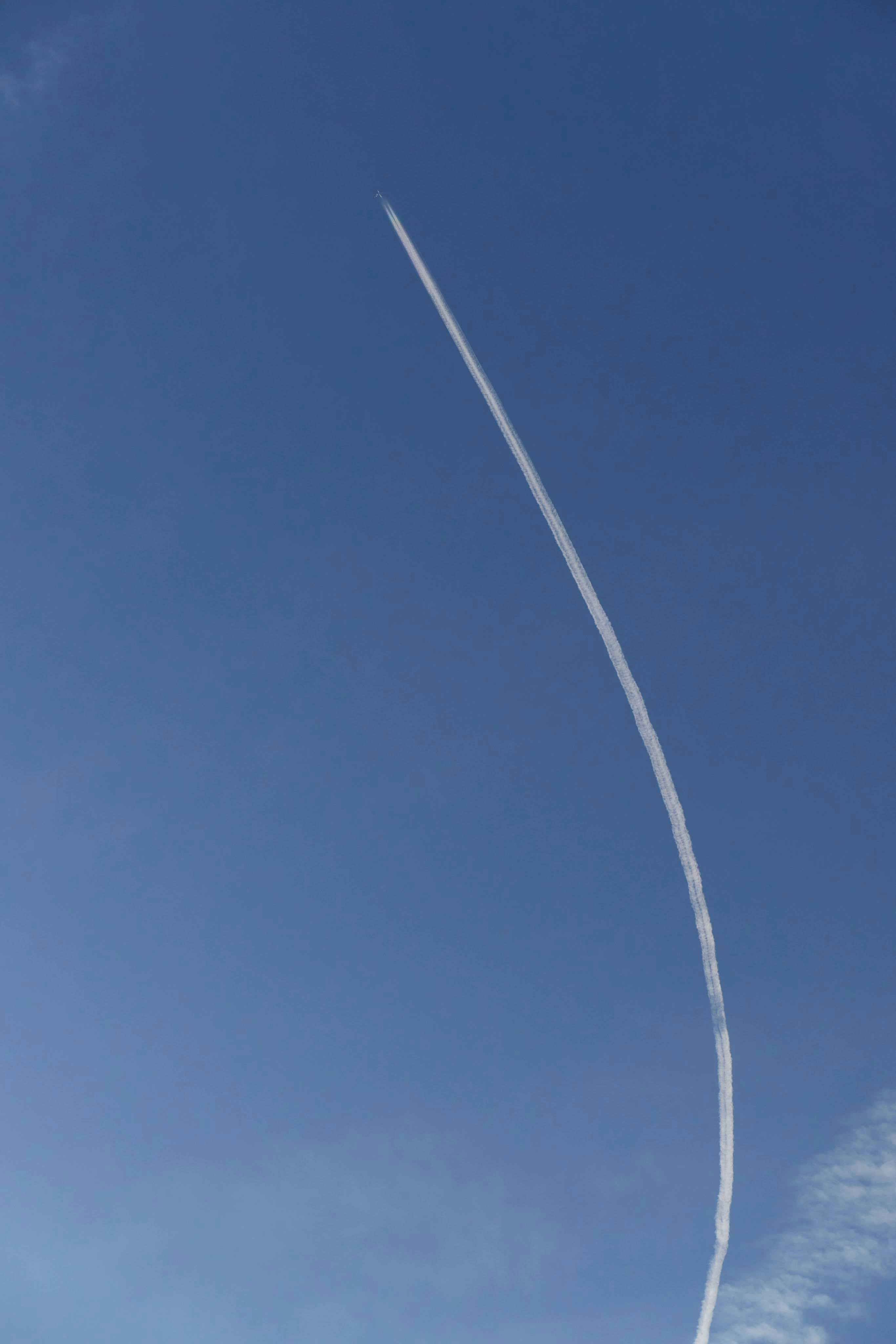 青空に伸びる細い飛行機雲の曲線
