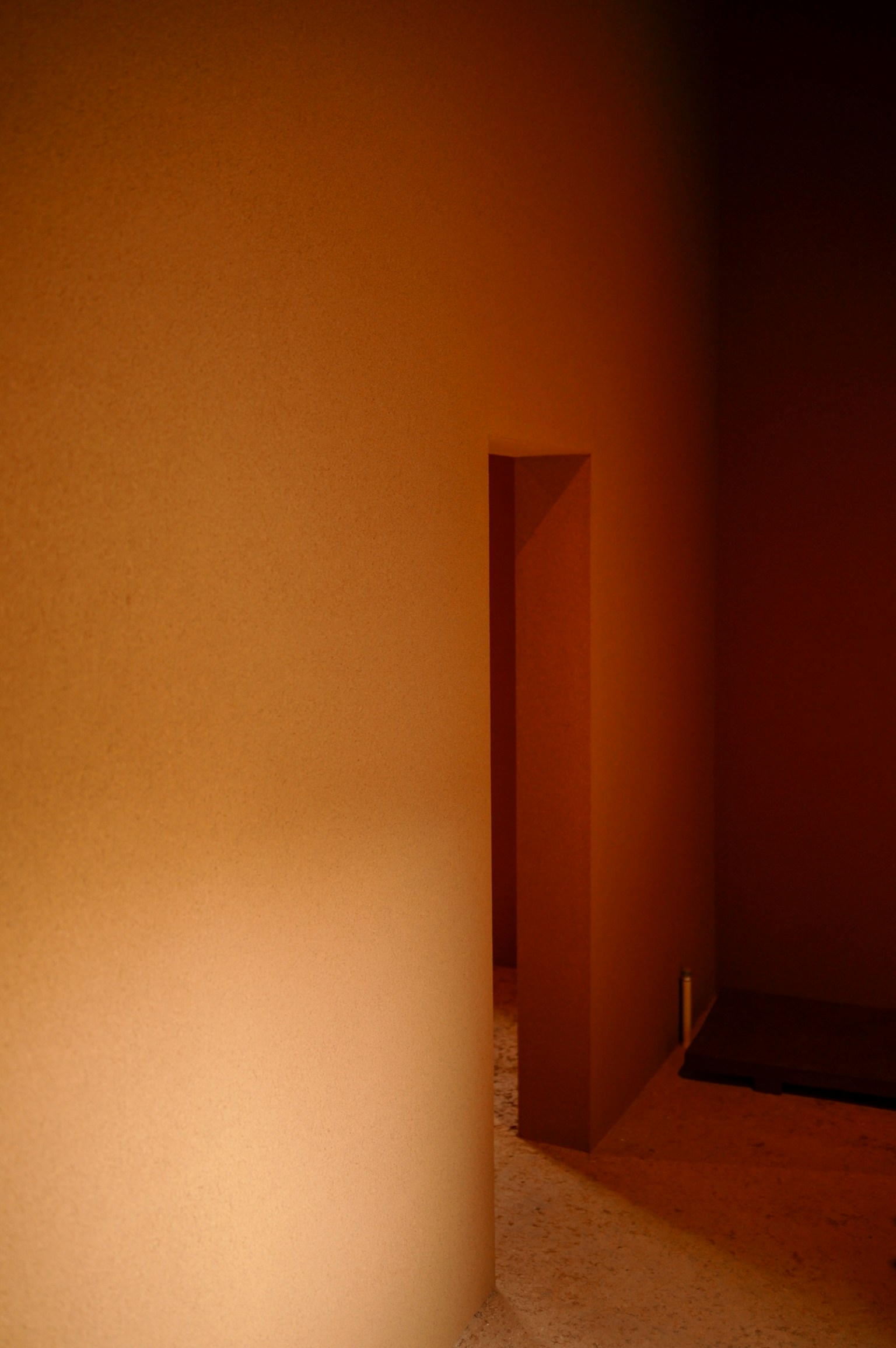 Ein einfacher Raum mit einer braunen Wand und einer kleinen Öffnung