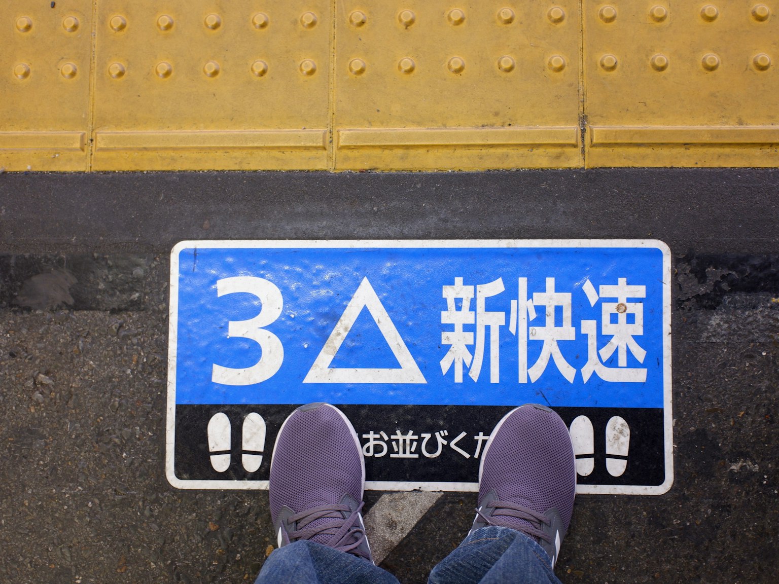 蓝色标志上有数字3、三角形和'新快速'字样的火车站台