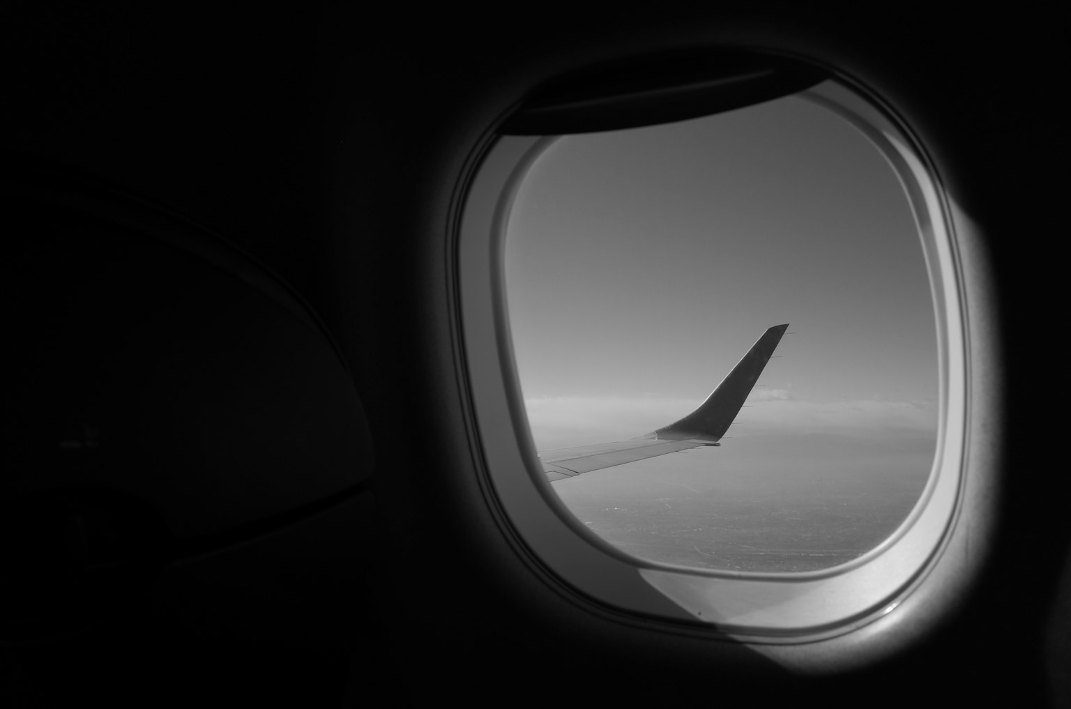 View from an airplane window showing the silhouette of a wing