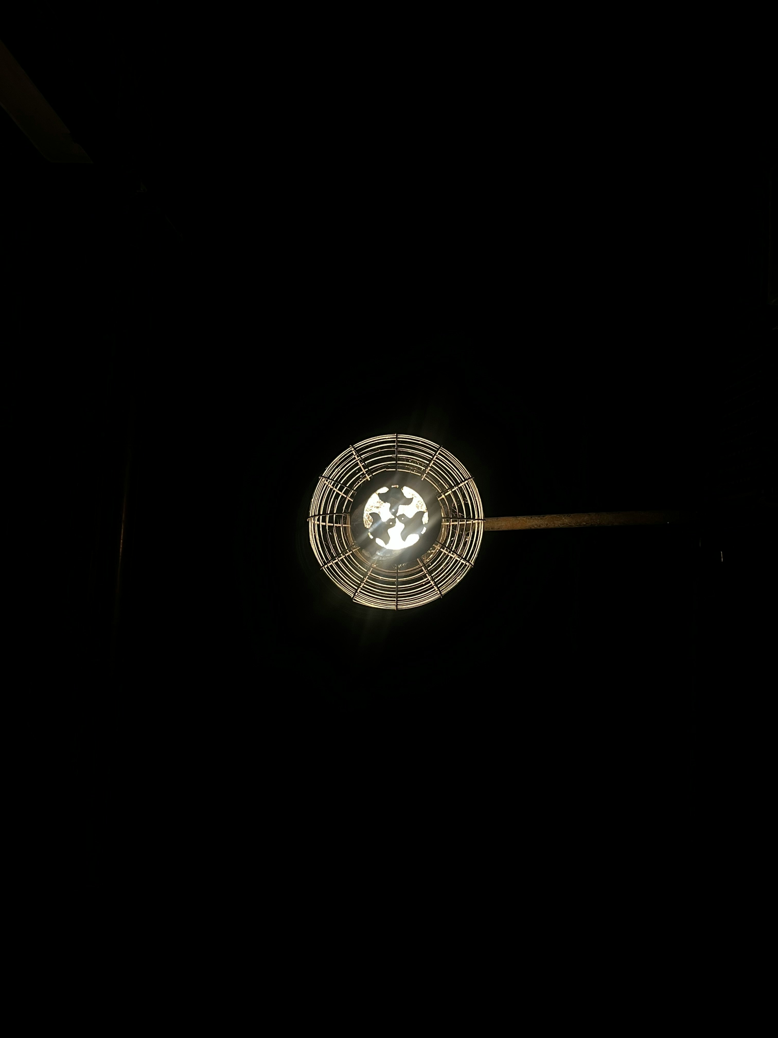 Ceiling fan light glowing against a dark ceiling