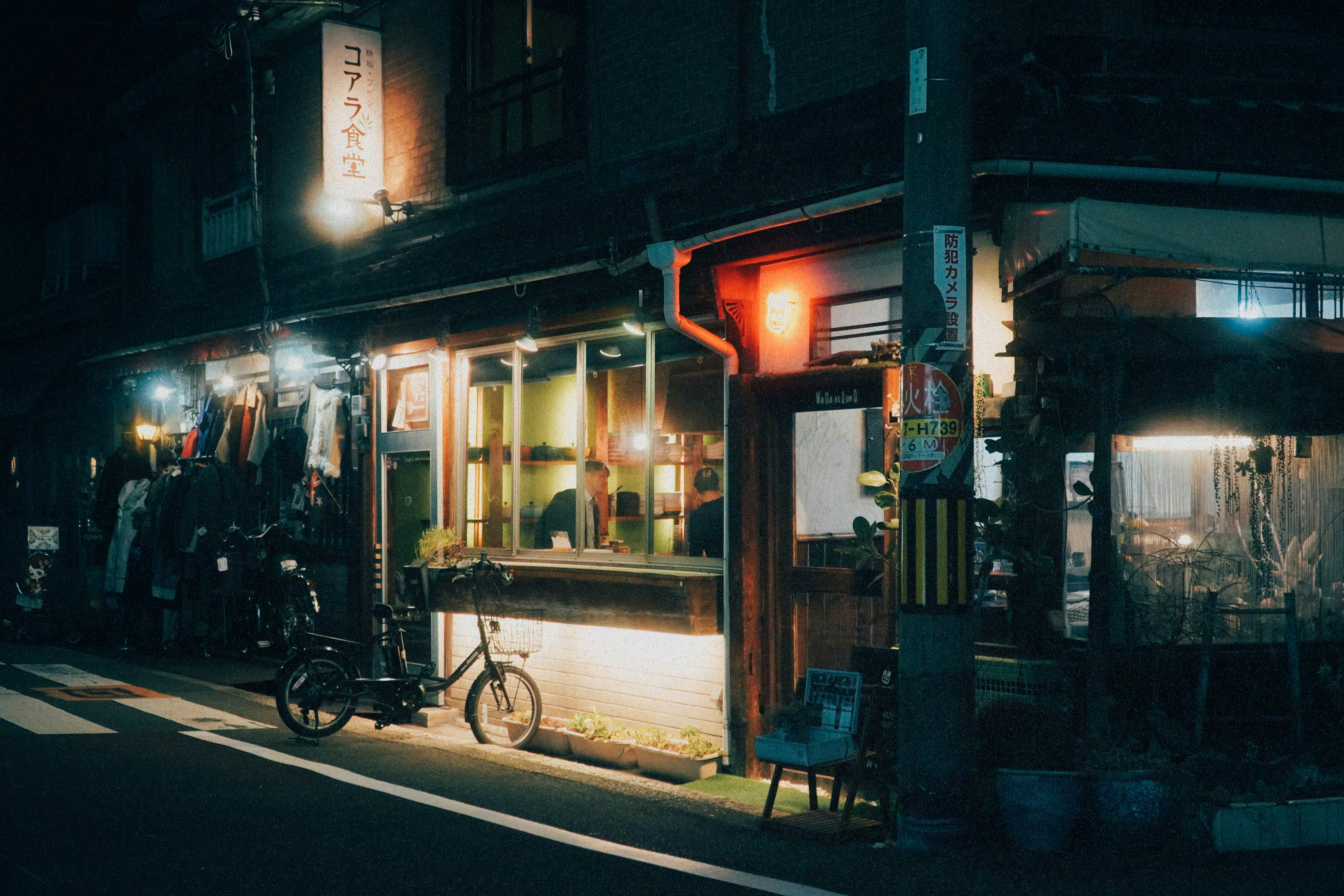 夜の路地に並ぶ自転車と飲食店の灯り