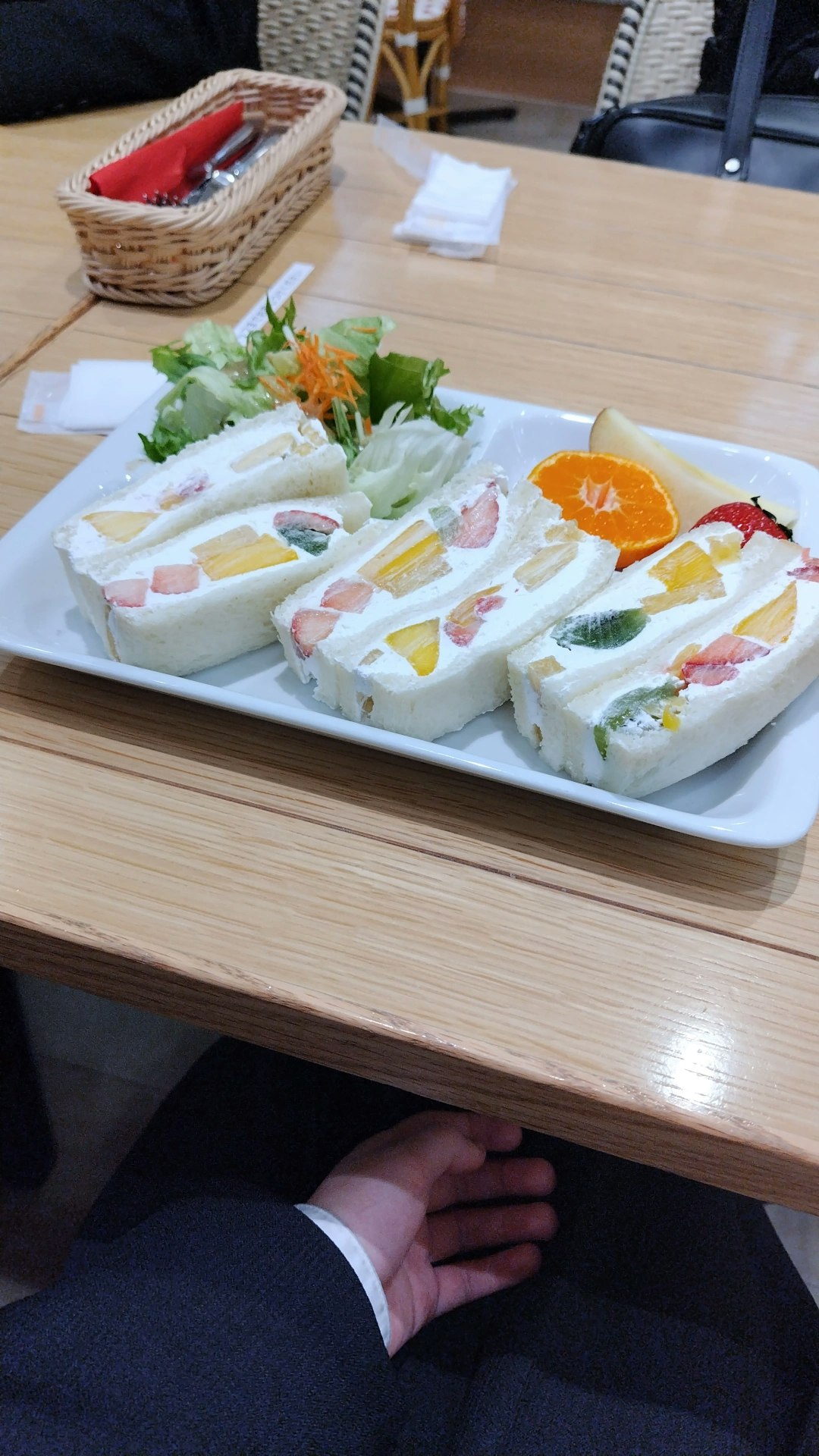 piring berisi aneka sandwich dan salad di atas meja kayu