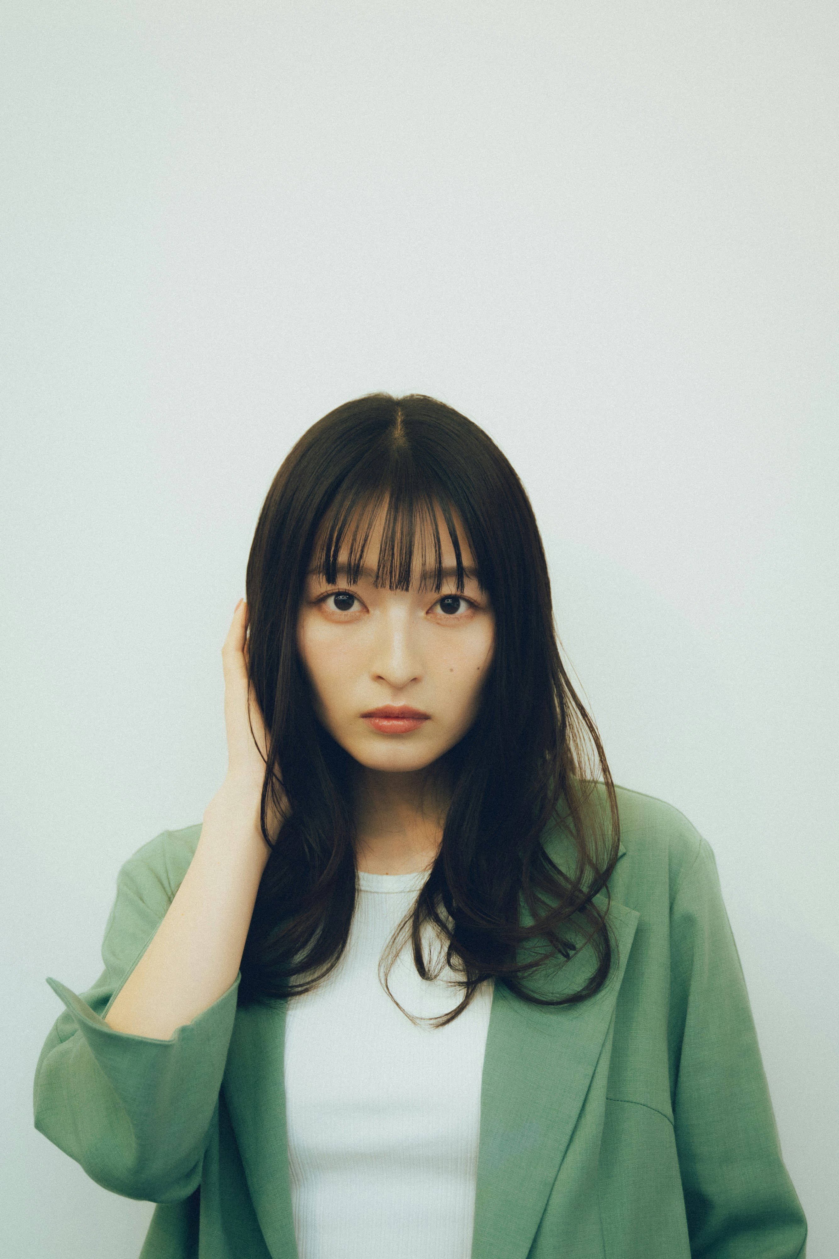 白背景で手を添える女性のポートレート