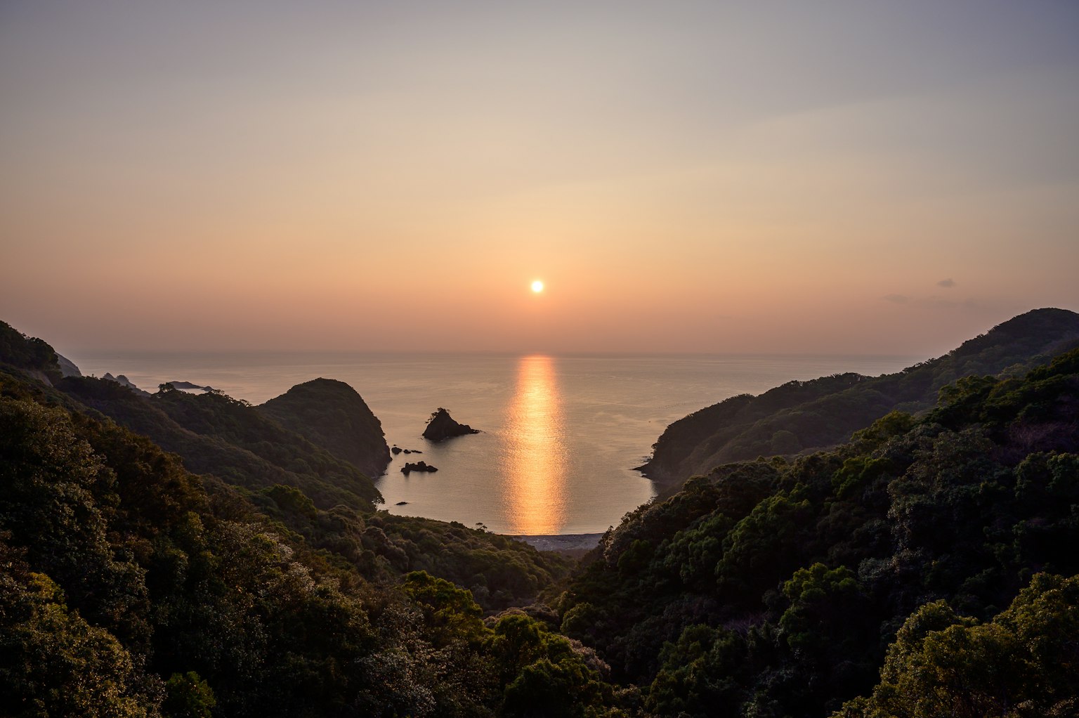 Vue pittoresque d'une côte avec un coucher de soleil se reflétant sur l'eau