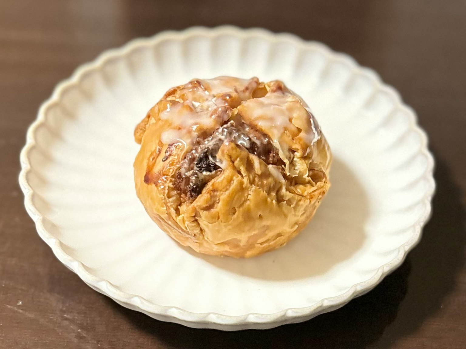 Une boule de pâtisserie sucrée posée sur une assiette blanche