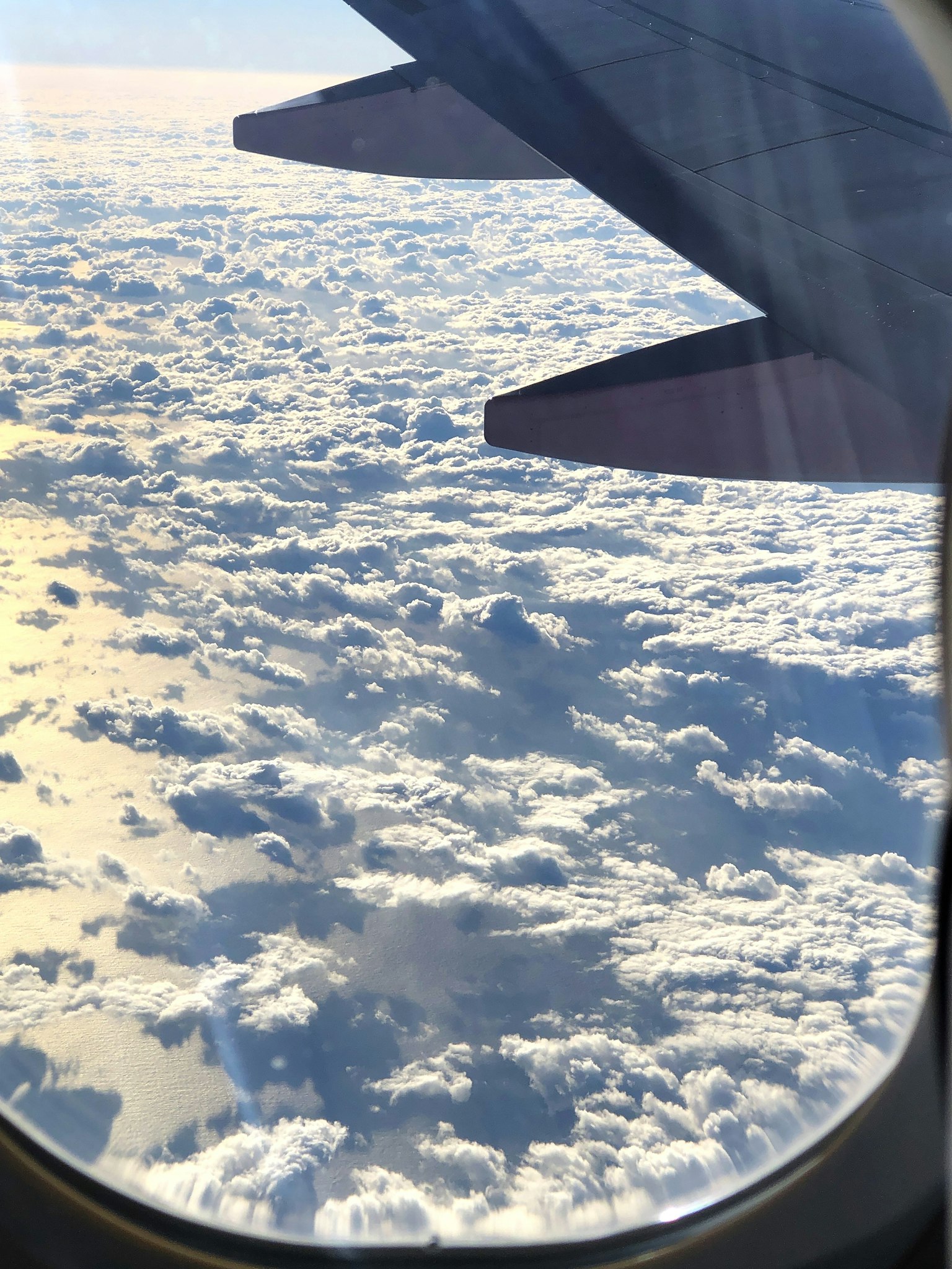 從飛機窗戶看到的雲和機翼的一部分
