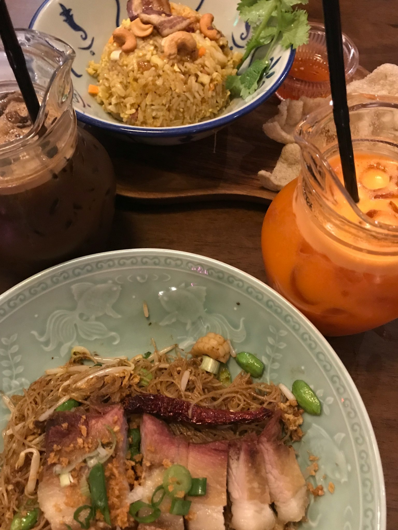 一張擺放著美味菜餚的桌子，包括炒麵和飲料