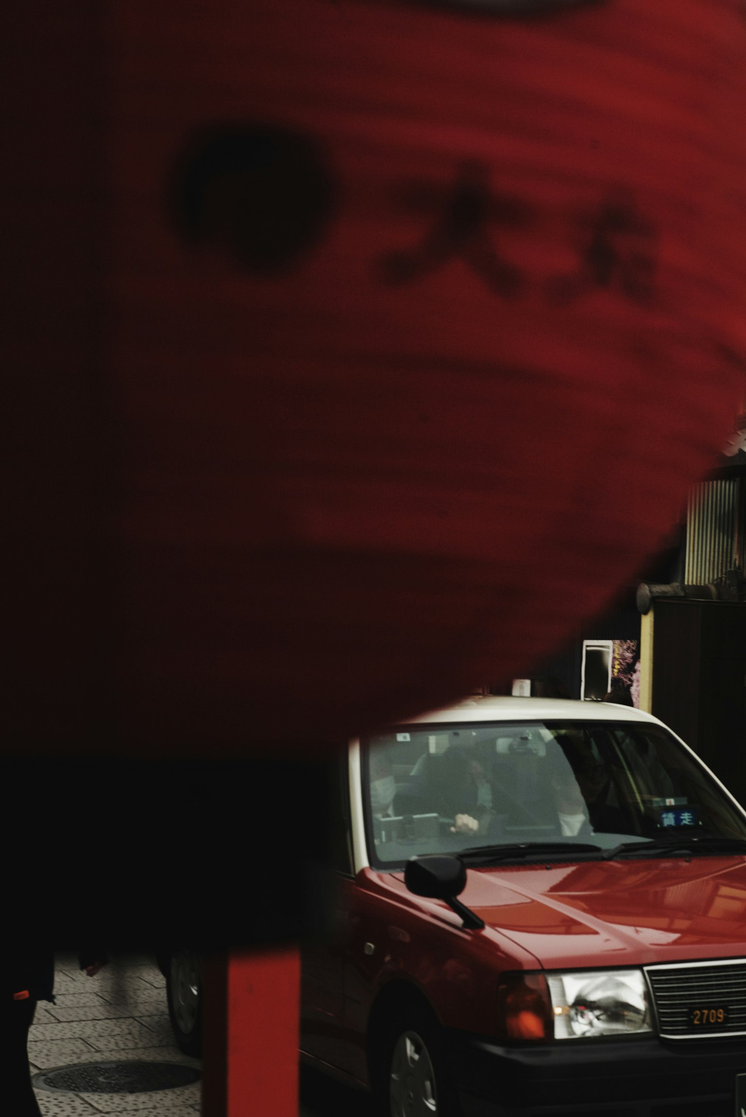 Street scene featuring a red lantern and a red taxi
