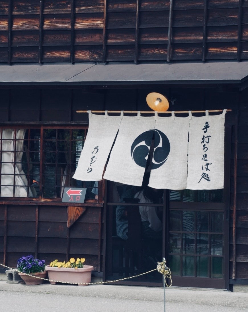 岐阜県の町家に揺れる暖簾と手書きのれんのある店先